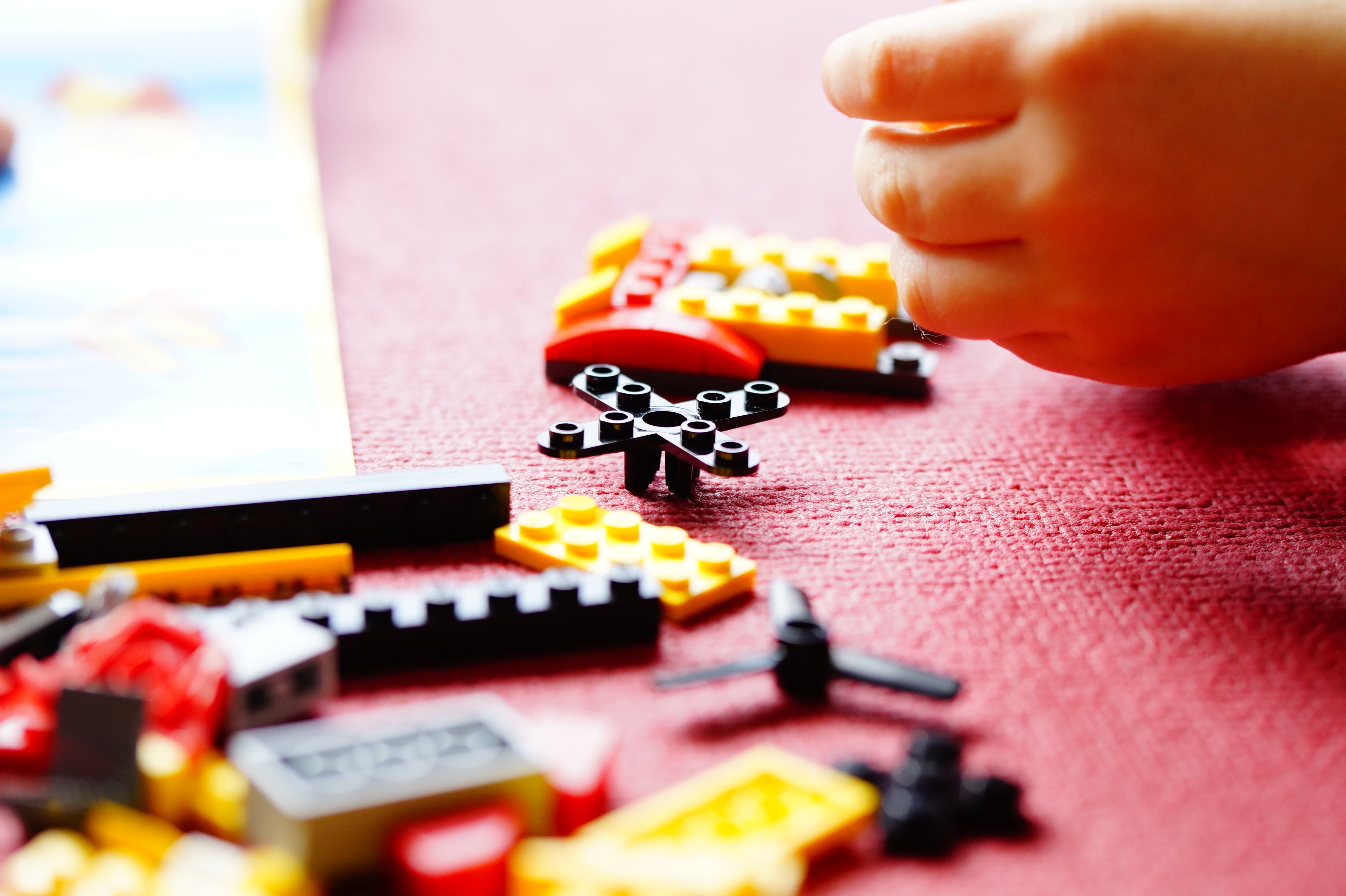 lego stones, construction toys, photo, closeup, finger, body part, toys, one person, toy, hand, unrecognizable person, holding, selective focus, clutter, HD Wallpaper
