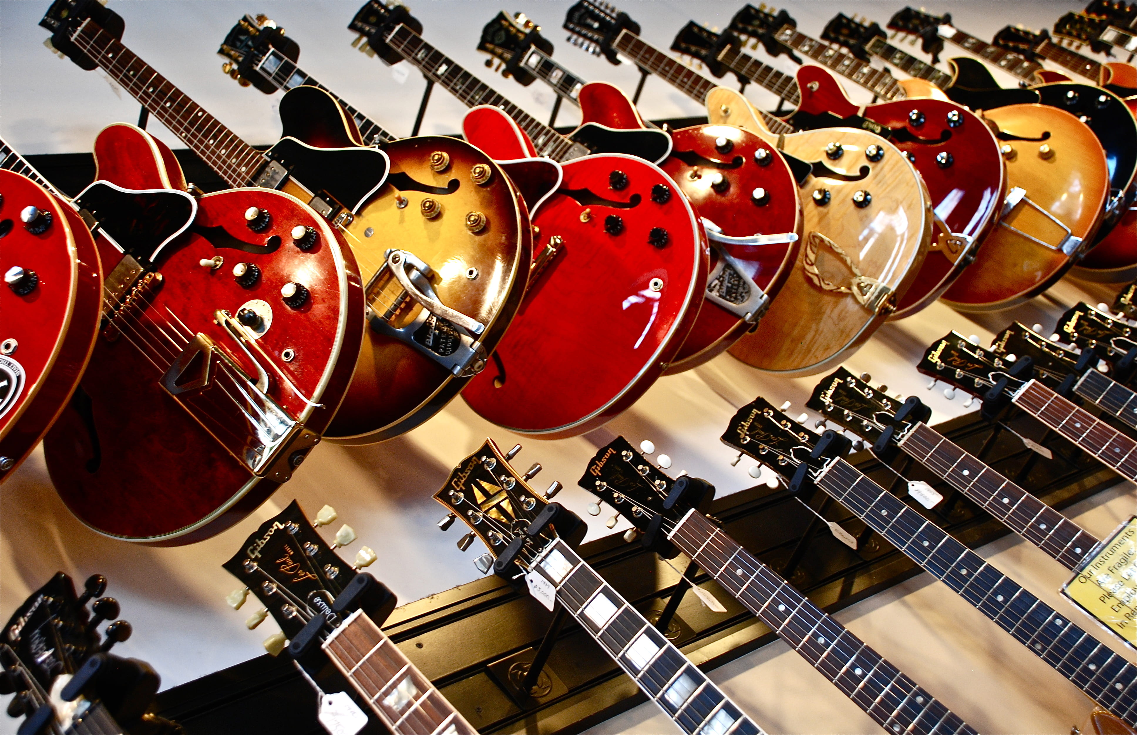 lot, 4K, large group of objects, neck, store, for sale, still life, wall, indoors, red, retail display, no people, string instrument, music, choice, arrangement, HD Wallpaper