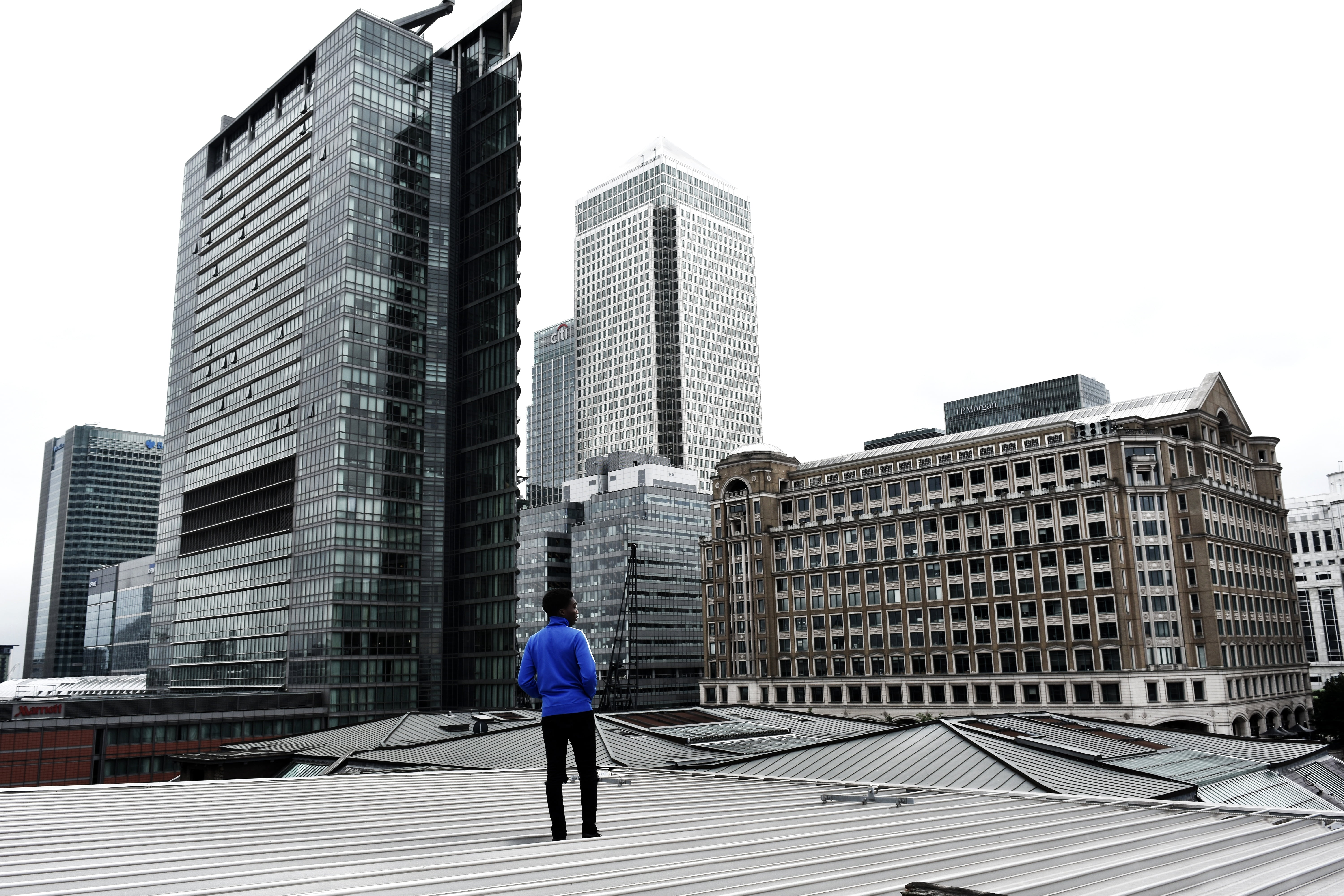 city life, built structure, office, 5K, outdoor, skyline, clear sky, modern, standing, real people, roof, one person, building exterior, urban, man, full length, HD Wallpaper
