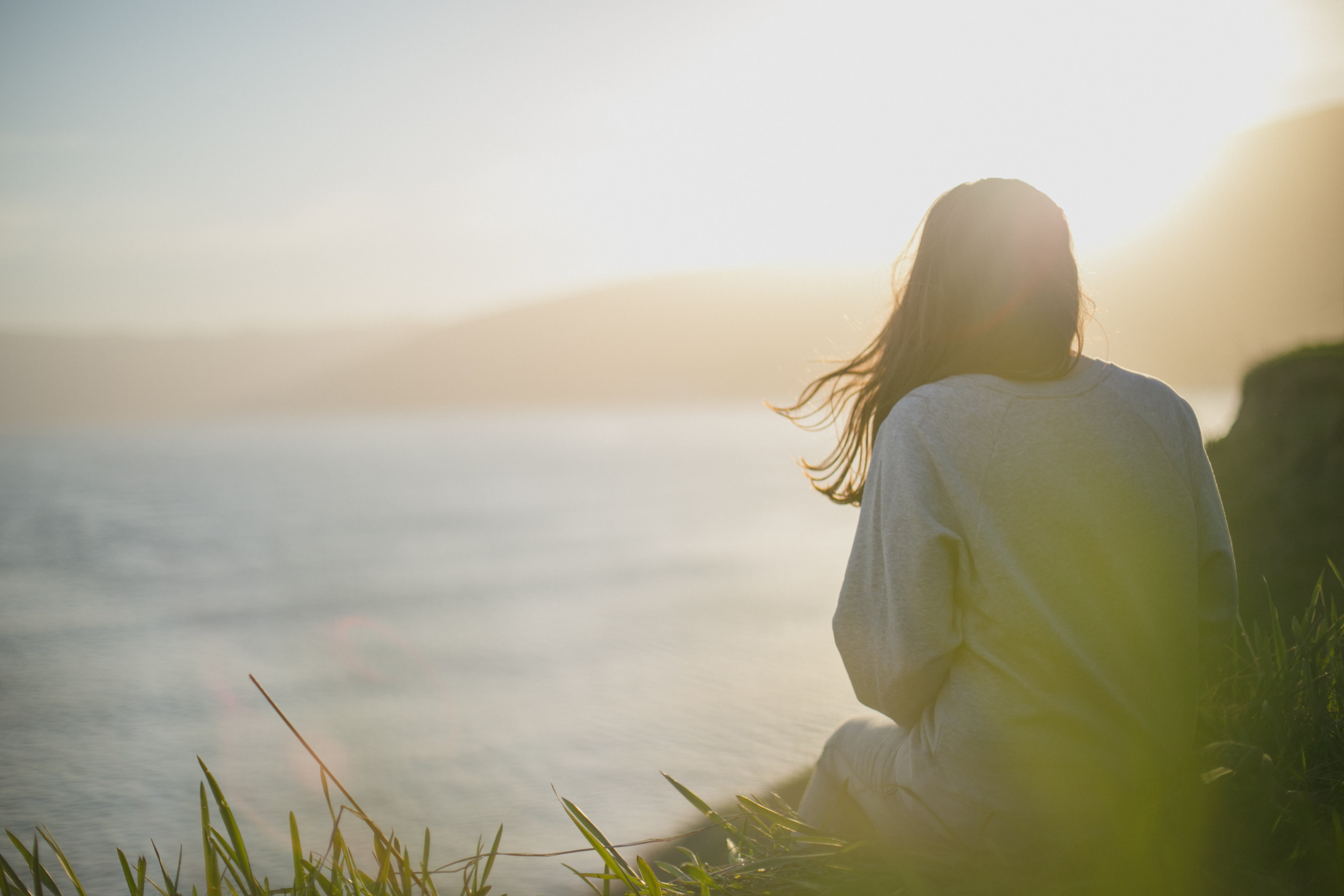 outdoors, nature, alone, girl, hair, seashore, grass, young Adult, land, summer, one Person, copy Space, coast, sitting, 4K, sunlight, sky, contemplation, HD Wallpaper