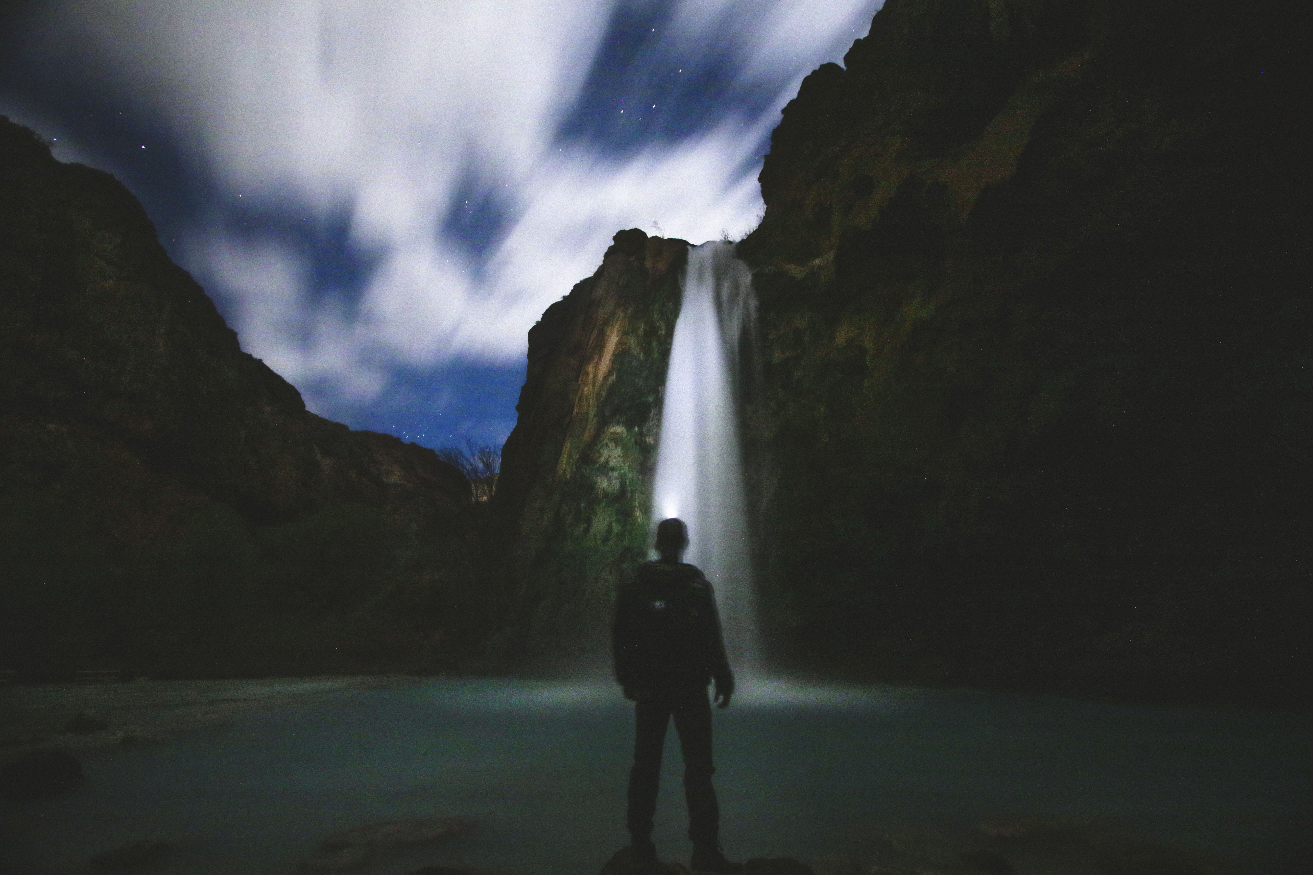 water, dark, land, night, nature, waterfalls, beauty in nature, front, river, sky, cloud - sky, men, outdoors, man, real people, rear view, clouds, one person, HD Wallpaper