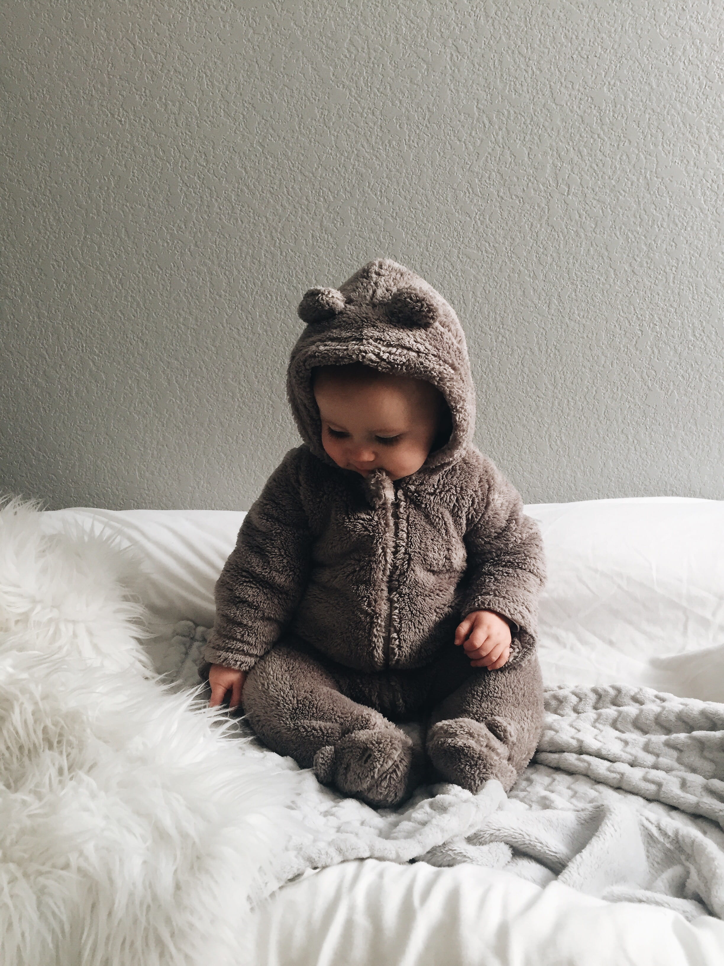 clothing, textile, fragile, bed, wearing, lifestyles, seating, winter, childhood, looking, 2K, gray, indoors, baby, toddler, real people, looking away, Phone HD Wallpaper