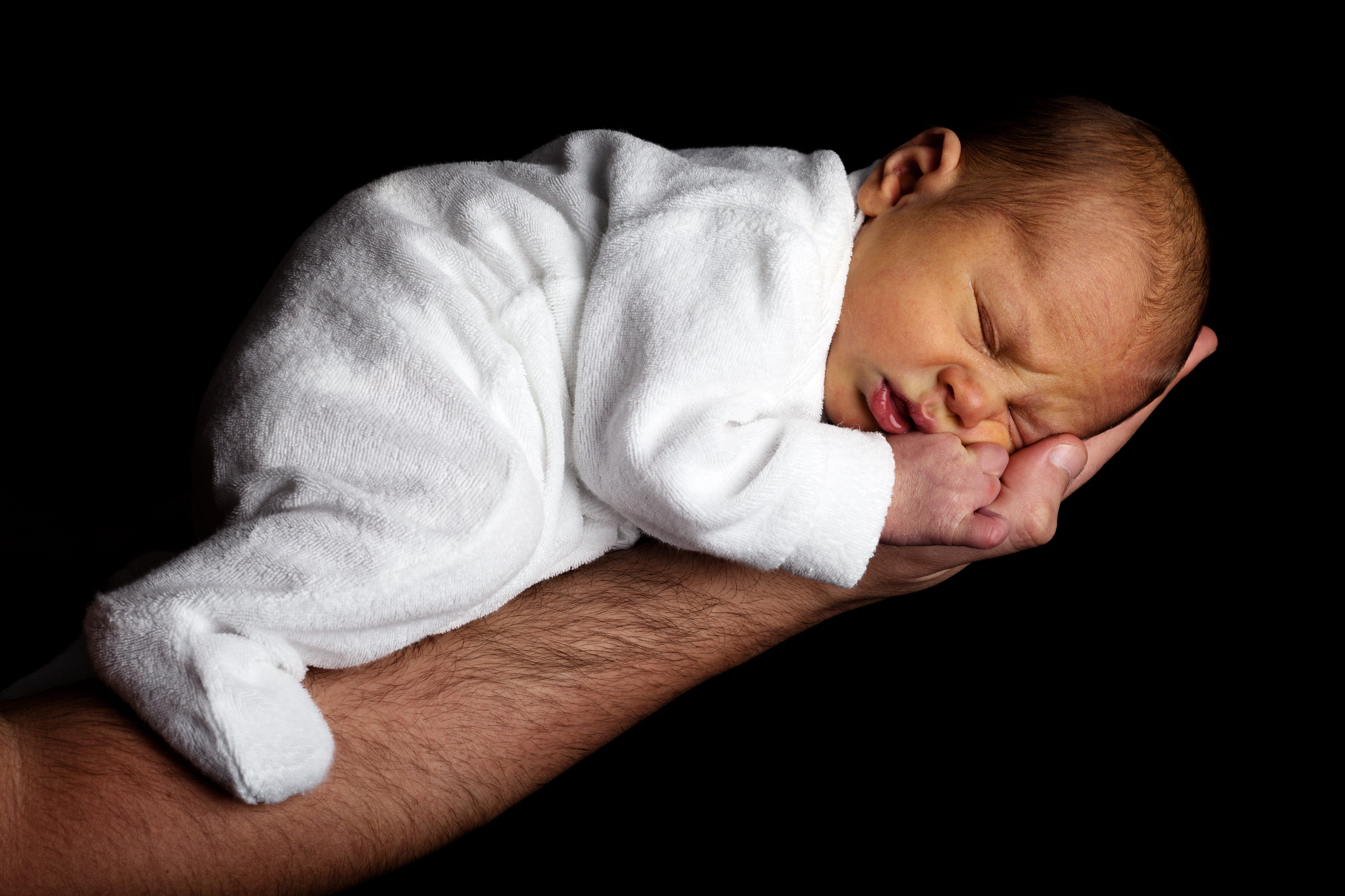 small, beginnings, one person, hand, men, onesie, black background, infant, cute, childhood, baby, eyes closed, lifestyles, life, softness, newborn, indoors, HD Wallpaper