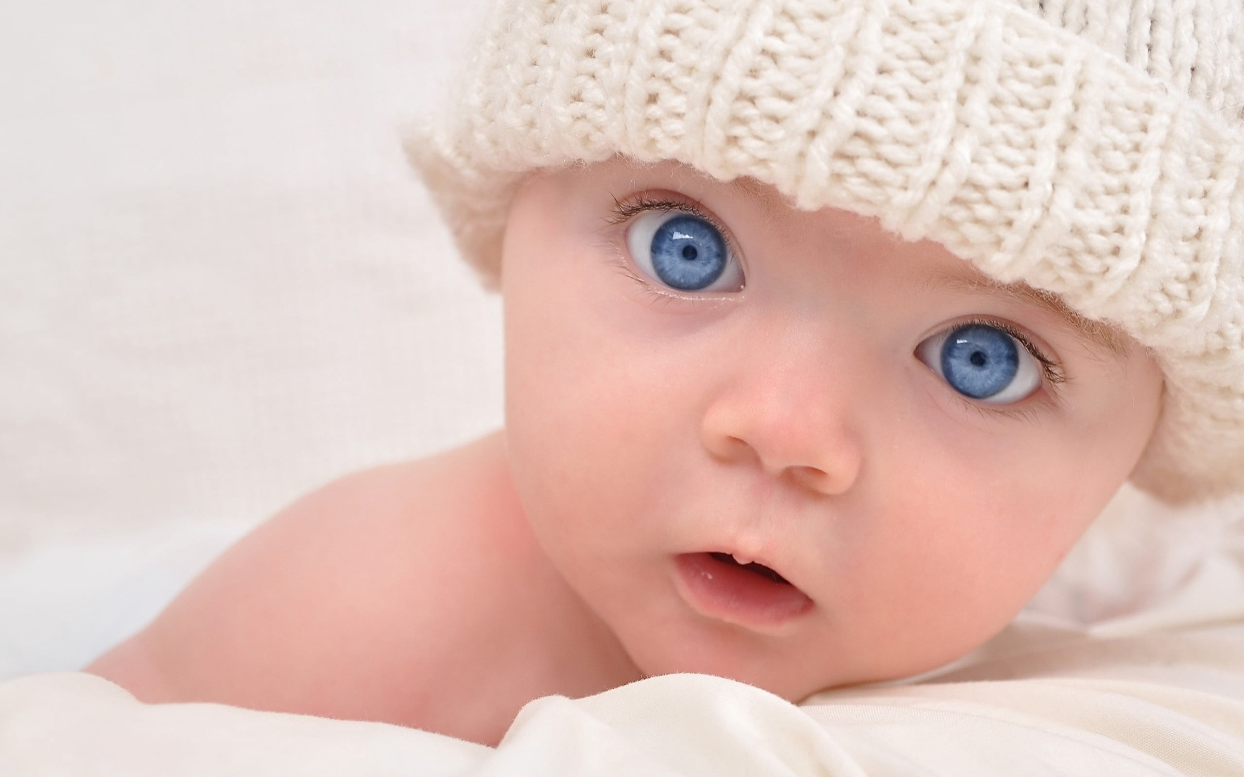 facial Expression, bed, real people, small, boys, looking, mouth, fun, emotion, newborn, blue, softness, comfortable, babies Only, joy, knit, portrait, HD Wallpaper