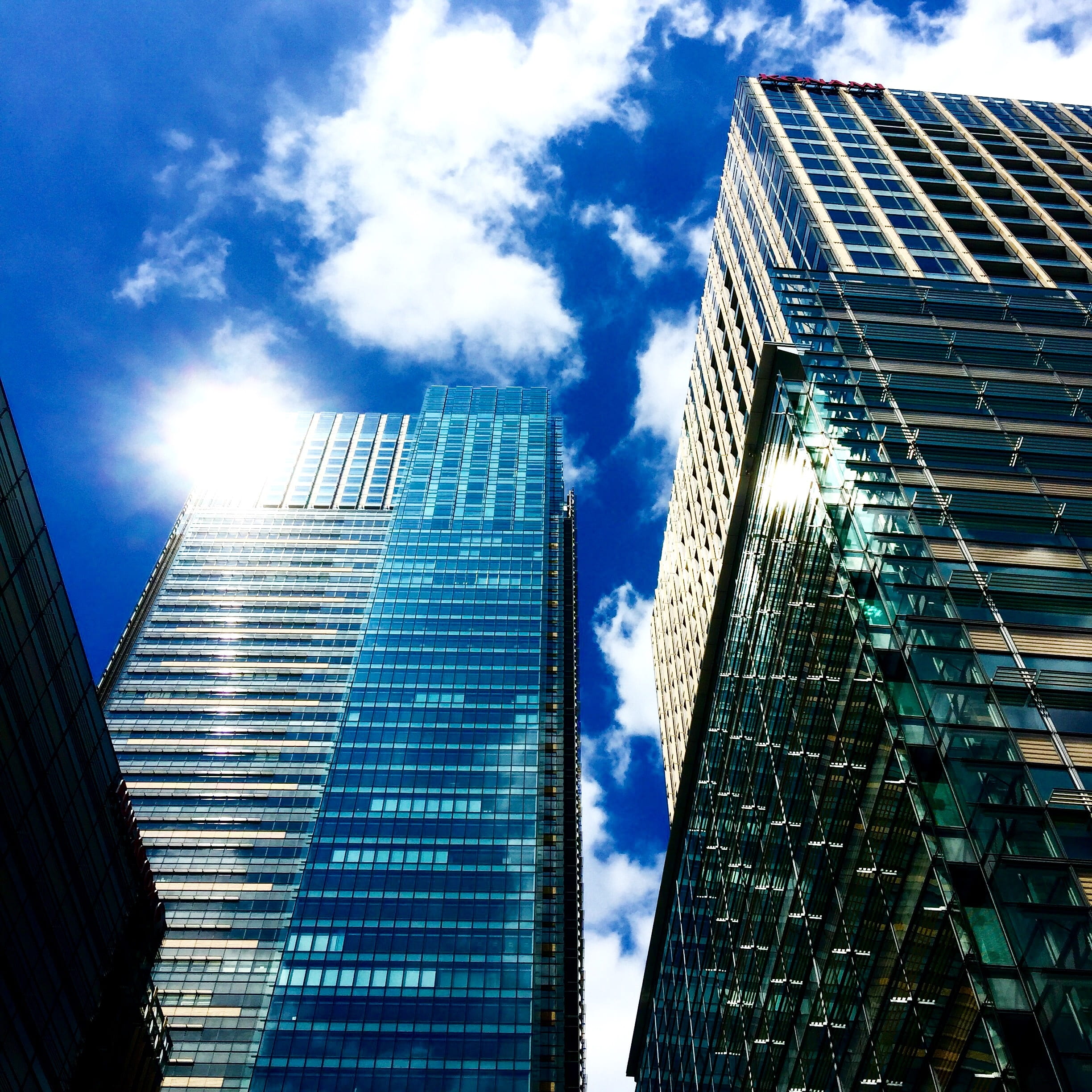 cityscape, view, exterior, building exterior, cloud - sky, futuristic, architecture, office, blue sky, low, lens flare, skyscraper, angle, modern, reflection, Phone HD Wallpaper