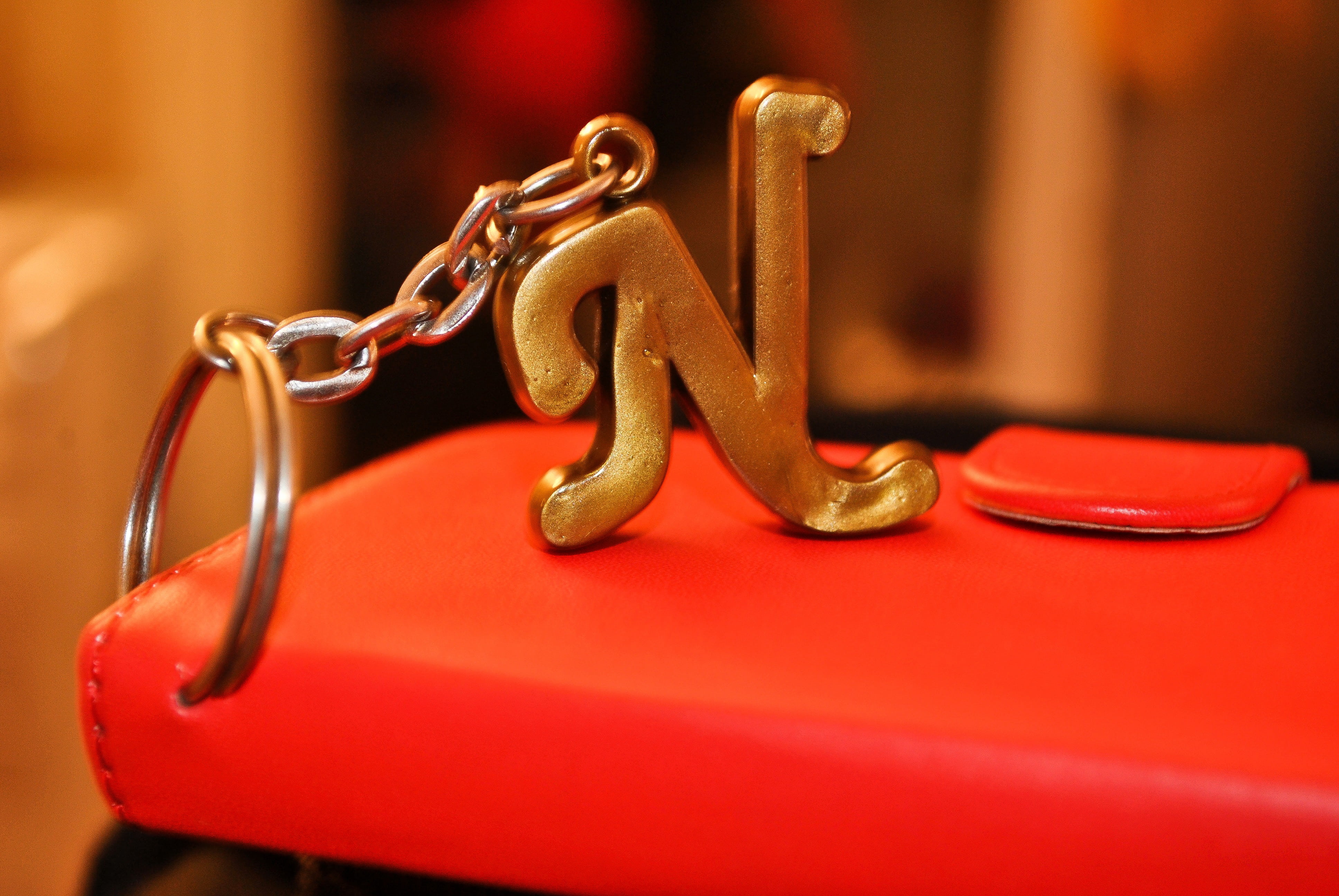 studio shot, keyring, history, selective focus, gold, chain, red, single object, photography, bright, character, abc, 4K, blurry, indoors, golden, glossy, HD Wallpaper