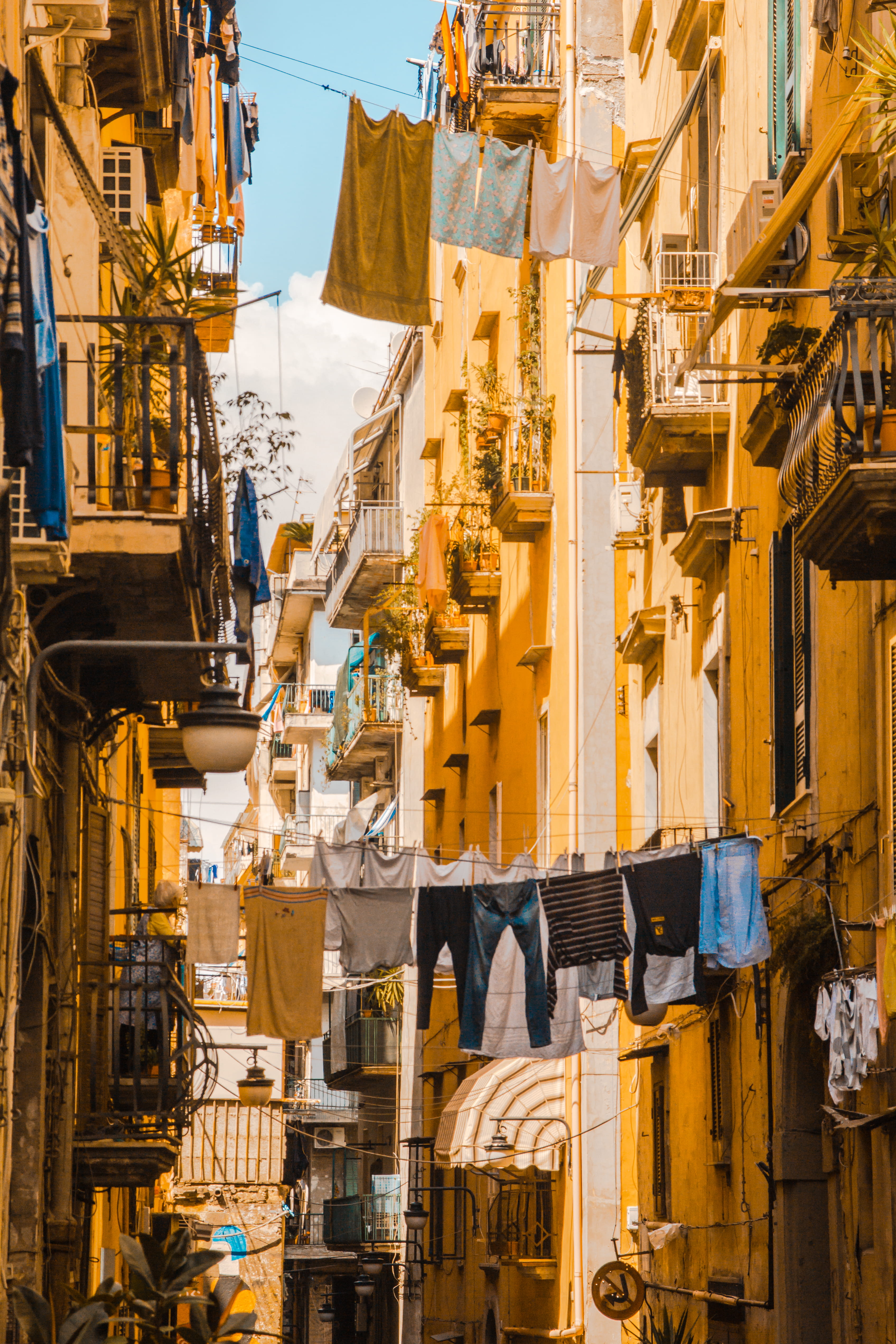 balcon, building exterior, city, yellow, home, hanged, clothing, architecture, retail, no people, house, built structure, wall, nature, day, building, residential district, Phone HD Wallpaper