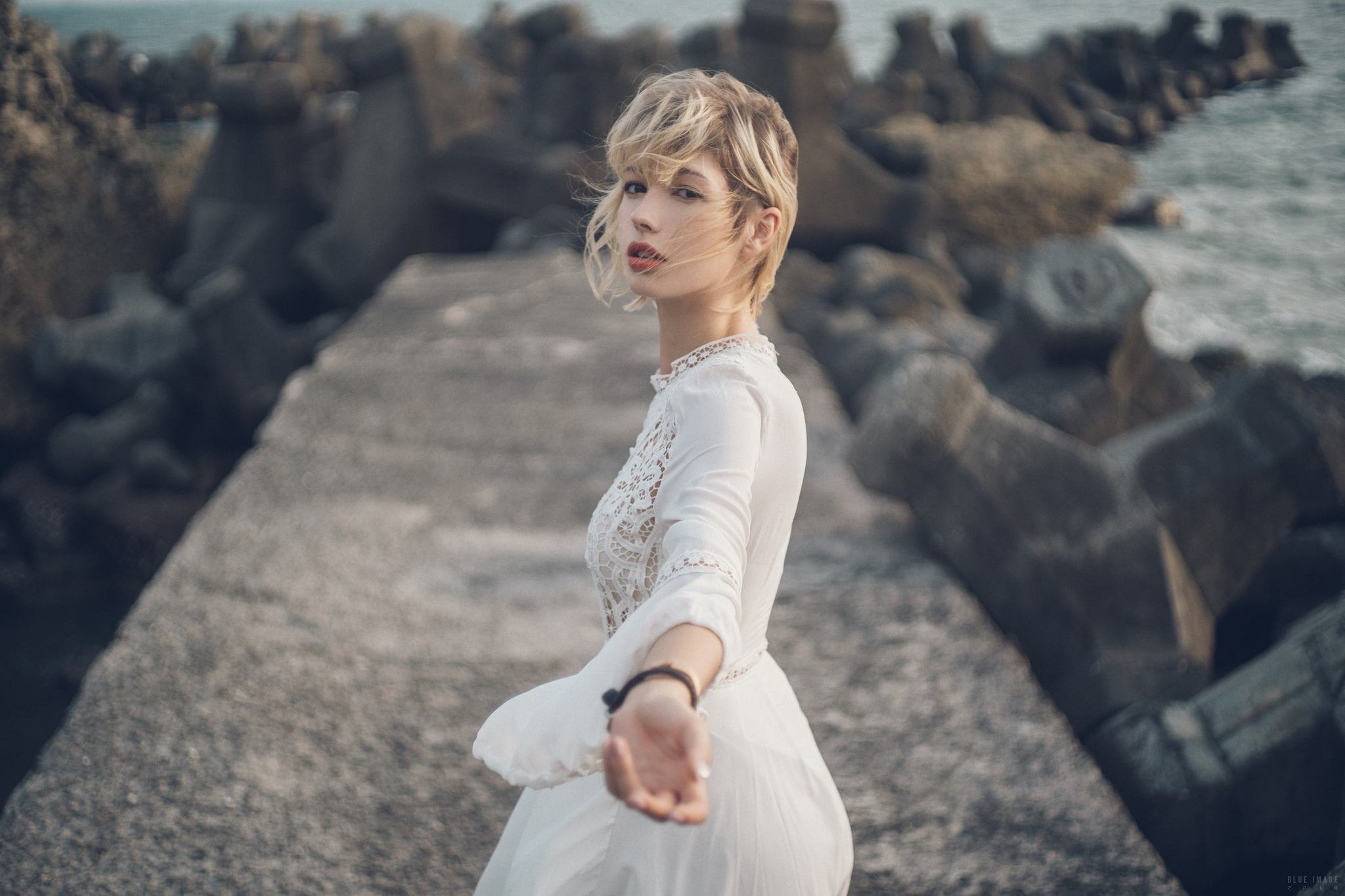 model, dress, rocks, sea, women outdoors, women, looking at viewer, blonde, hair in face, short hair, depth of field, 1080P, HD Wallpaper