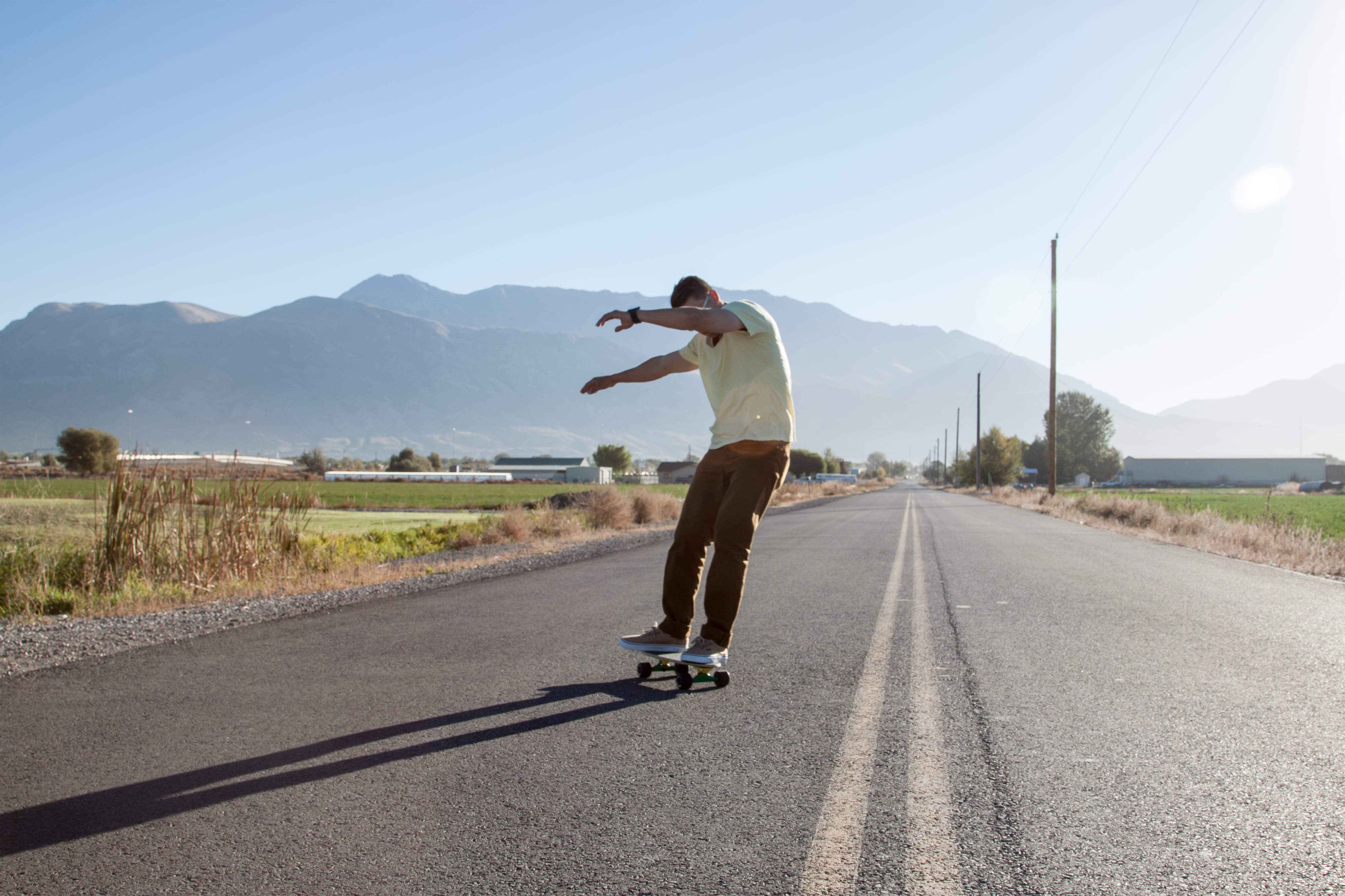 diminishing perspective, man, day, human arm, mountain range, leisure activity, road, outdoors, sport, adventure, adult, street, skateboarding, sky, guy, HD Wallpaper