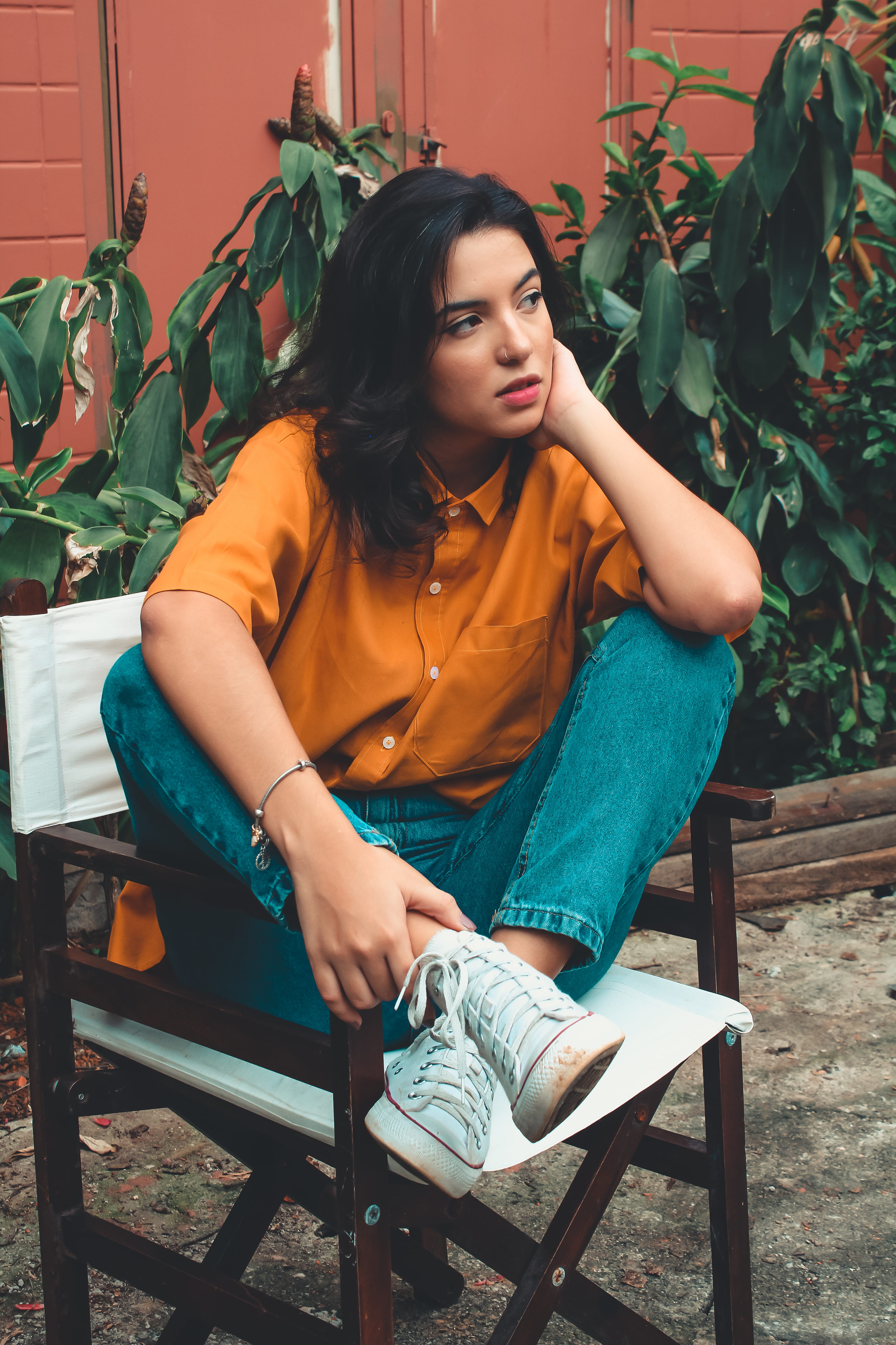 casual clothing, wooden, lady, facial expression, 5K, seat, posing, plant, young women, leisure activity, sneakers, female, pose, real people, wooden chair, Phone HD Wallpaper