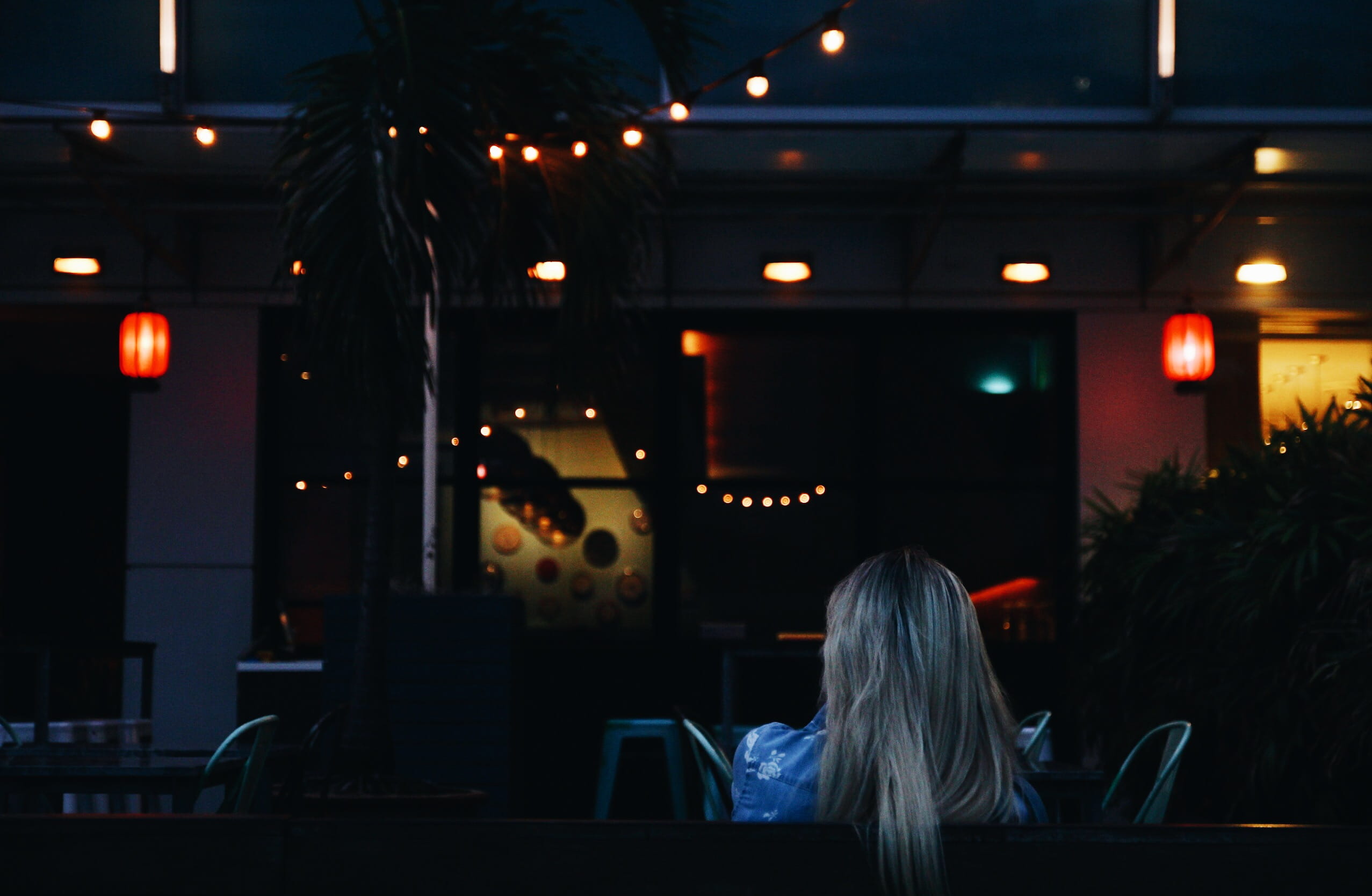 woman, towards, painted, wall, chair, room, woman in blue, blond hair, night, real people, people, 1080P, table, adult, indoors, hairstyle, lantern, shirt, HD Wallpaper