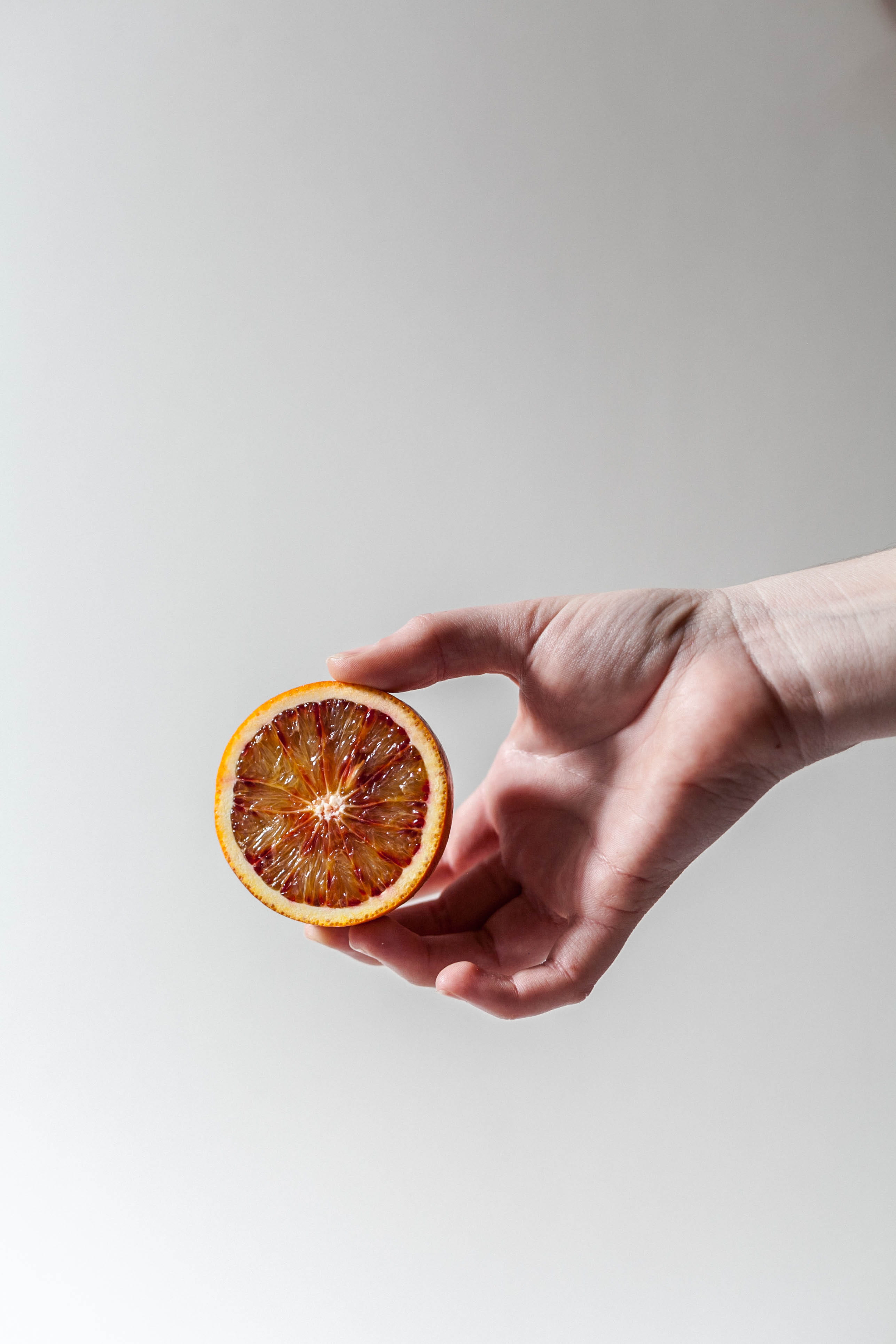 close-up, grapefruit, studio shot, minimal, person, 4K, slice, one person, food, human hand, indoors, human body part, wellbeing, gray, cross section, Phone HD Wallpaper