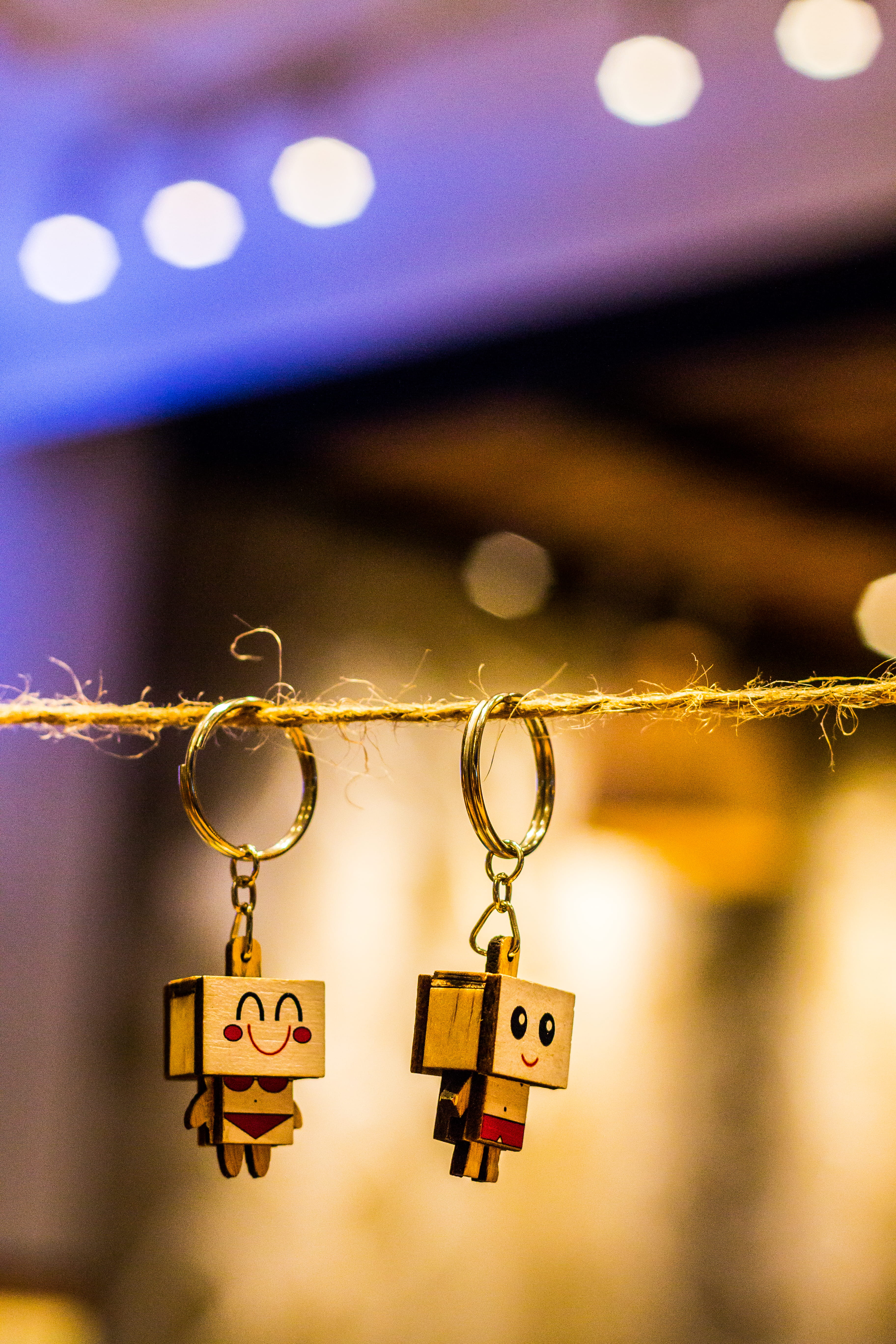 blurred background, bokeh, indoors, creativity, illuminated, chains, night, wooden, two, brown, decoration, text, keychain, thread, electricity, photography, Phone HD Wallpaper