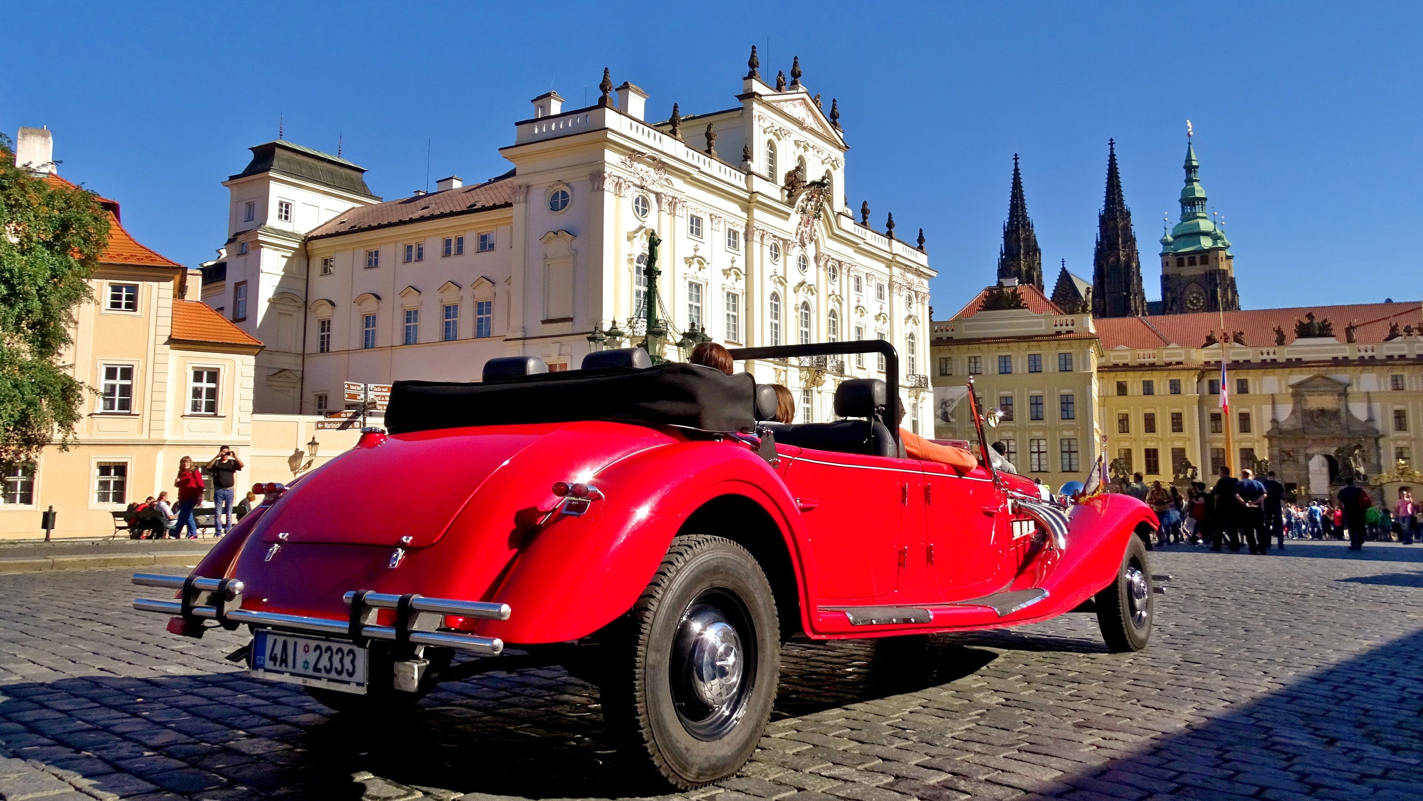 motor vehicle, red, outdoors, town square, car, near, building exterior, history, street, transportation, prague, incidental people, day, city, white, daytime, HD Wallpaper