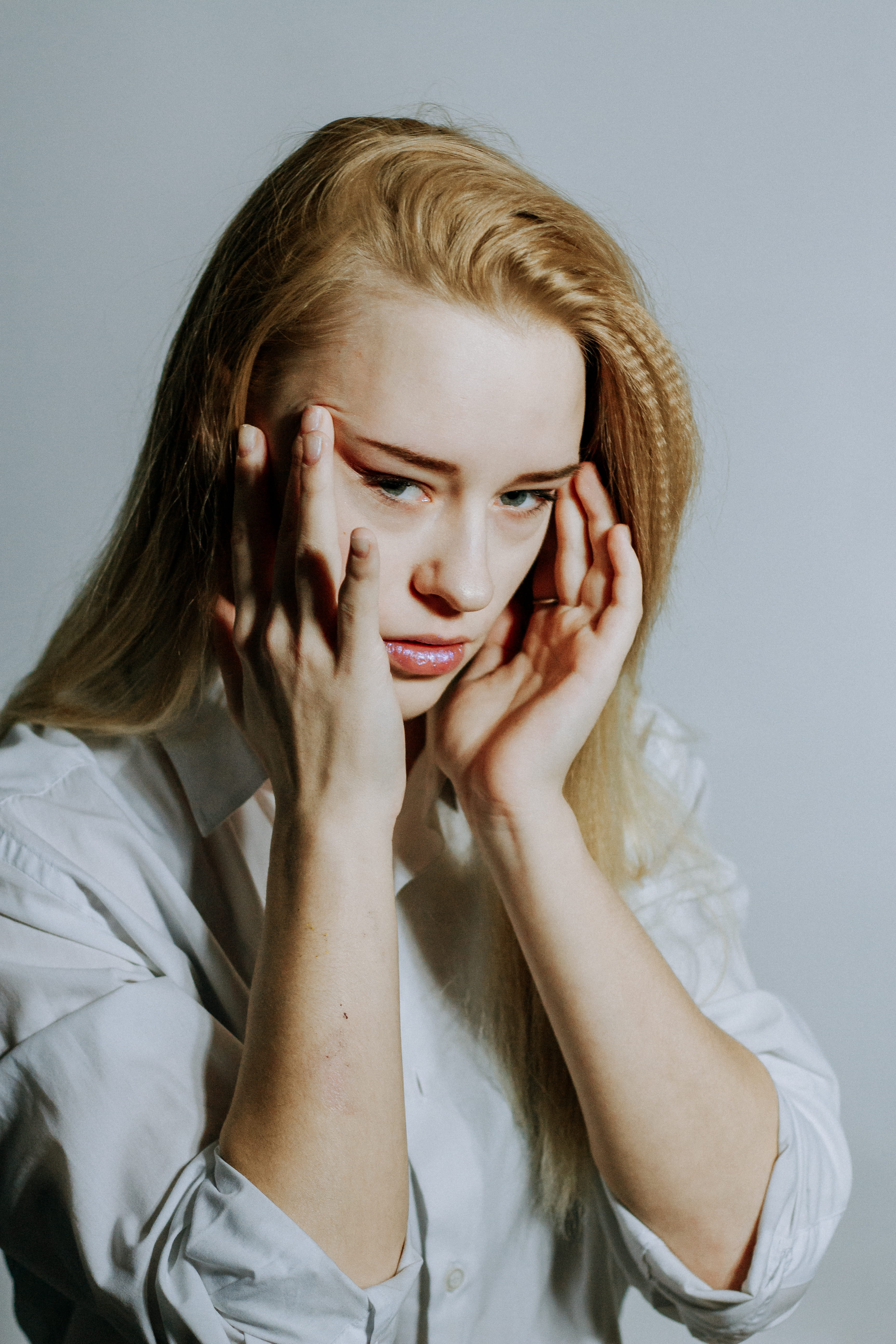 front view, head in hands, photo, stress, young adult, studio shot, hairstyle, beauty, headache, 5K, beautiful woman, portrait, pain, human face, gray background, Phone HD Wallpaper