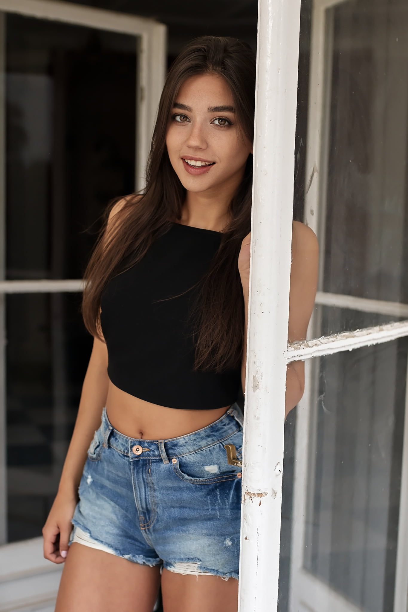 jeans, 1080P, Paweł Paoro Witkowski, shorts, women, tank top, long hair, Maja Strojek, brunette, doorways, black clothing, denim, smiling, Phone HD Wallpaper