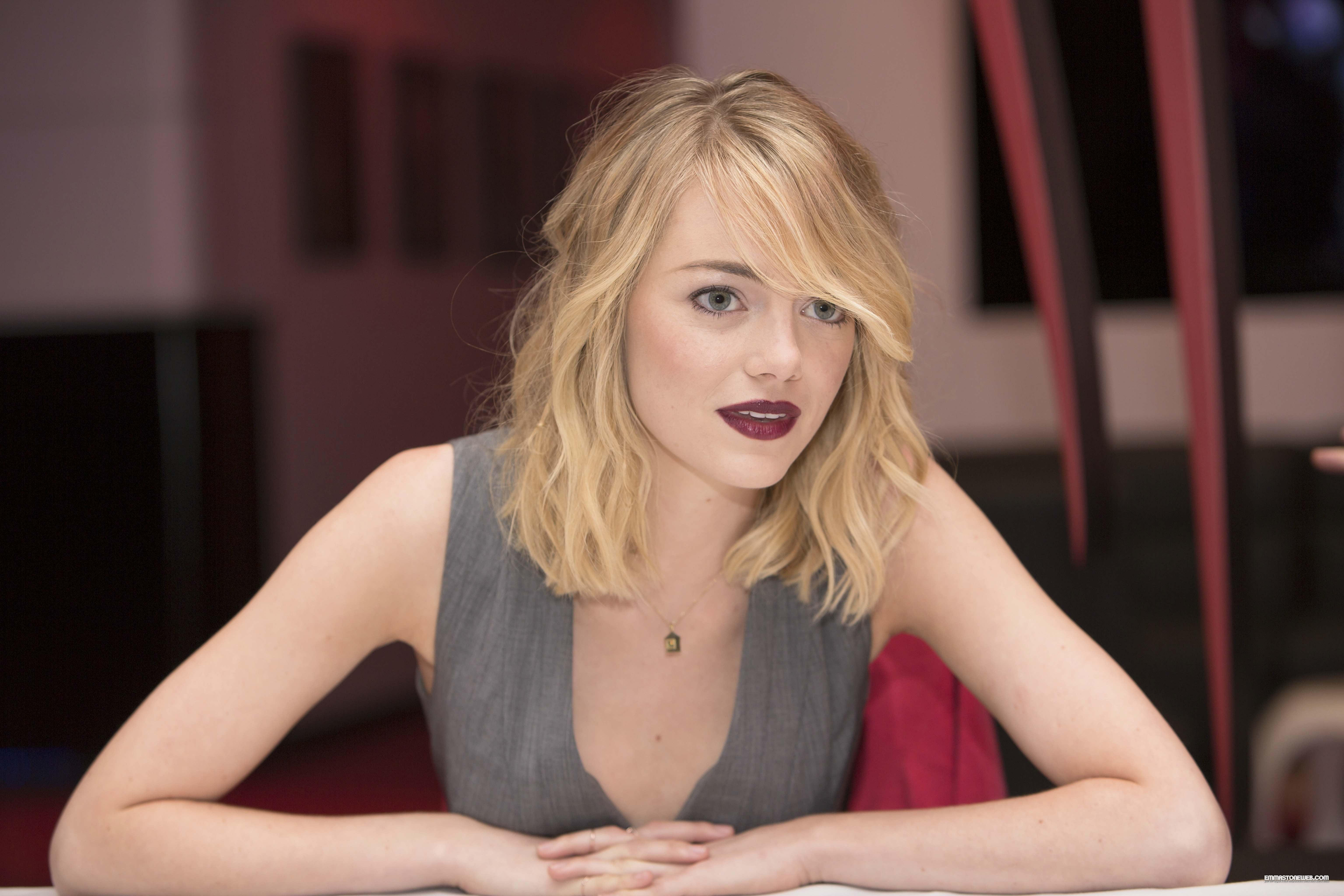 Emma Stone, mouth open, front view, lifestyles, blond hair, contemplation, long hair, woman, red lipstick, sitting, looking at camera, gray, sleeveless top, HD Wallpaper