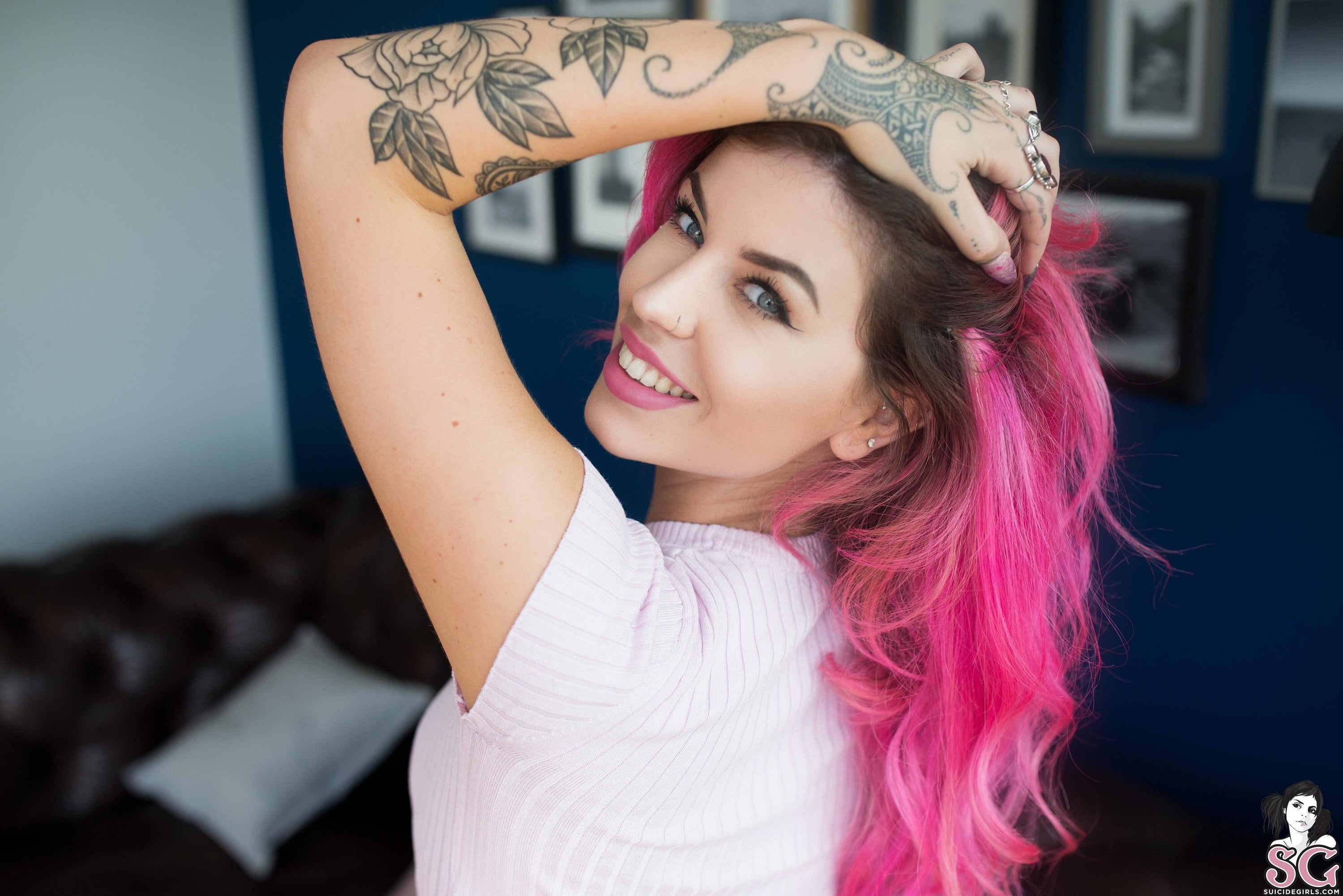 face, painted nails, couch, model, 2K, Aemelia Suicide, smiling, looking at viewer, women, cushions, pink hair, hand on head, depth of field, picture frames, HD Wallpaper