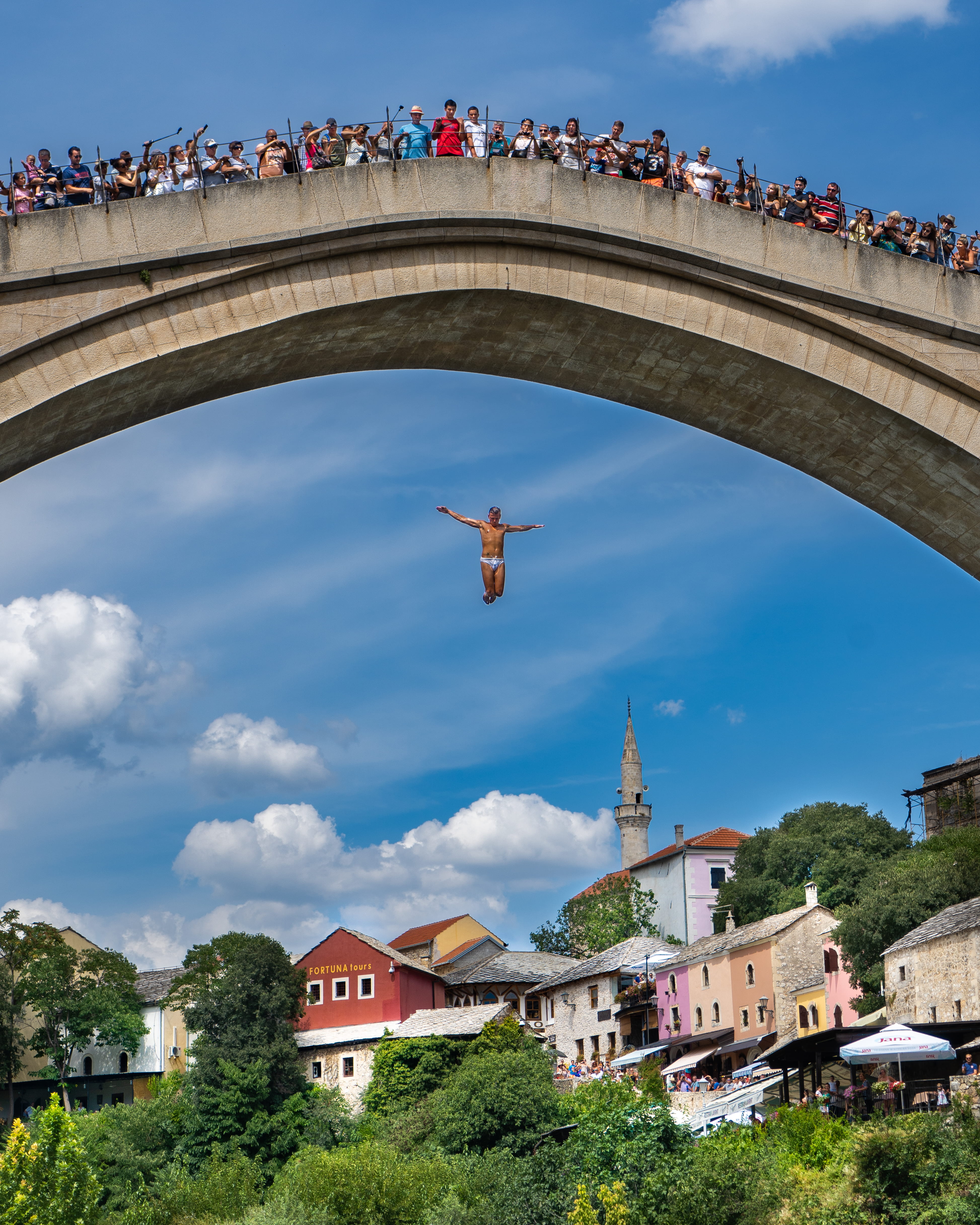 daytime, built structure, people, jumping, arch bridge, the past, building, city, sky, history, bosnium, cloud - sky, bridge, mostar, stari most, travel destinations, Phone HD Wallpaper