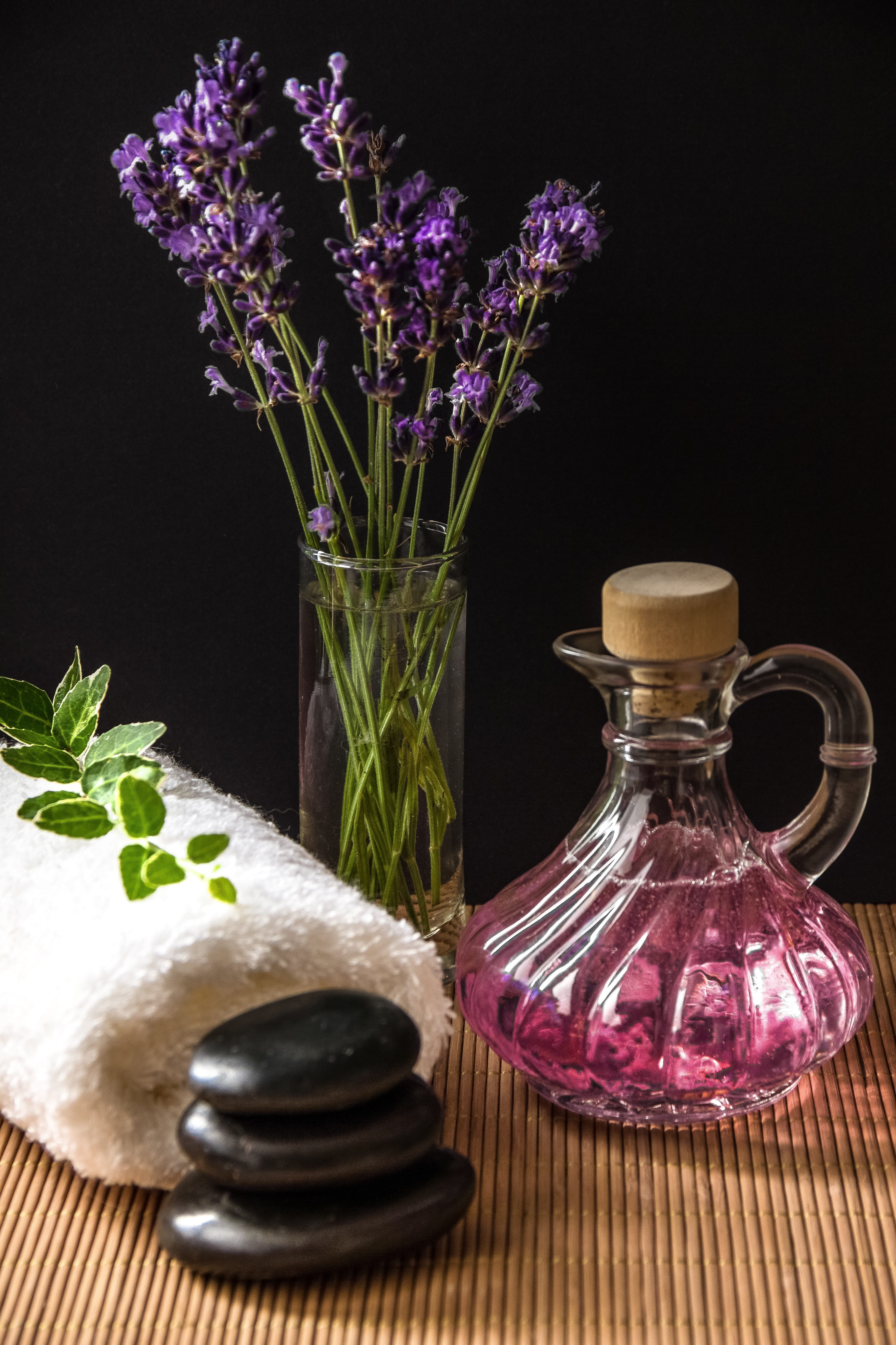 flowering plant, freshness, vase, container, 5K, beauty, plant, table, herbs, relaxation, light, stones, nature, black background, towel, spa, flower arrangement, Phone HD Wallpaper