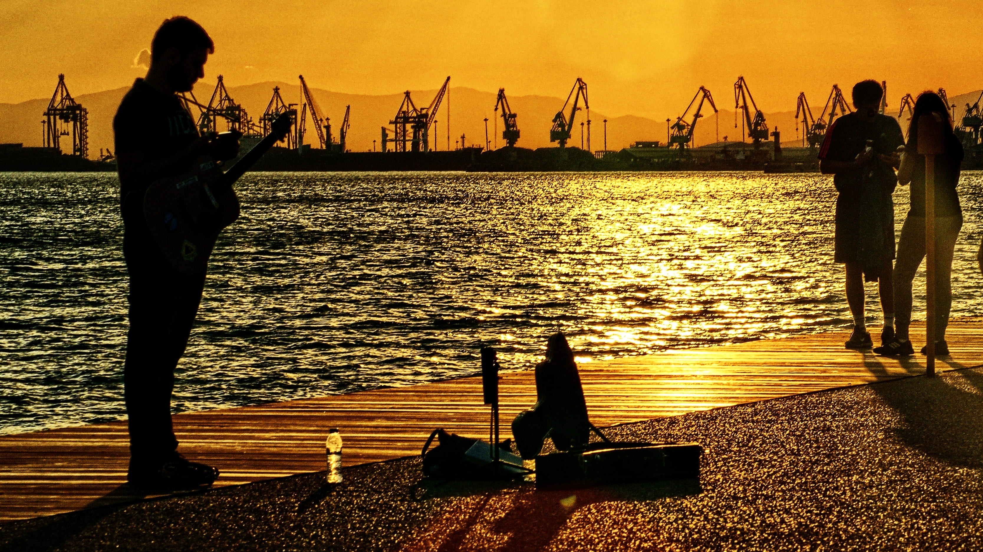 sky, 2K, sea, guitar, crane - construction machinery, thessaloniki, sunset, men, arts culture and entertainment, port, standing, transportation, the piper, HD Wallpaper