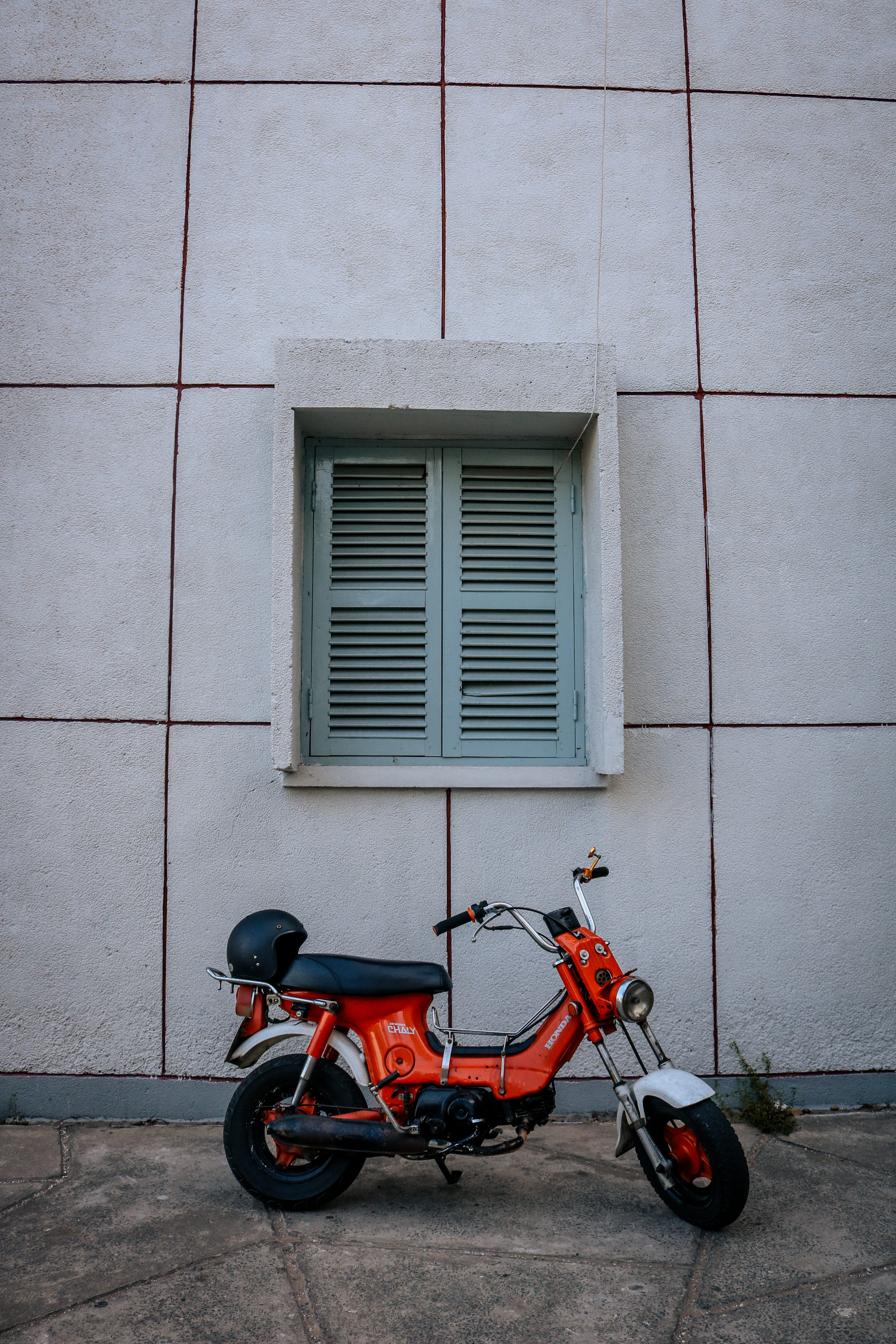 daytime, window, wheels, pavement, 5K, shutter speed, red, city, day, built structure, exterior, street, wall - building feature, moped, wall, helmet, Phone HD Wallpaper