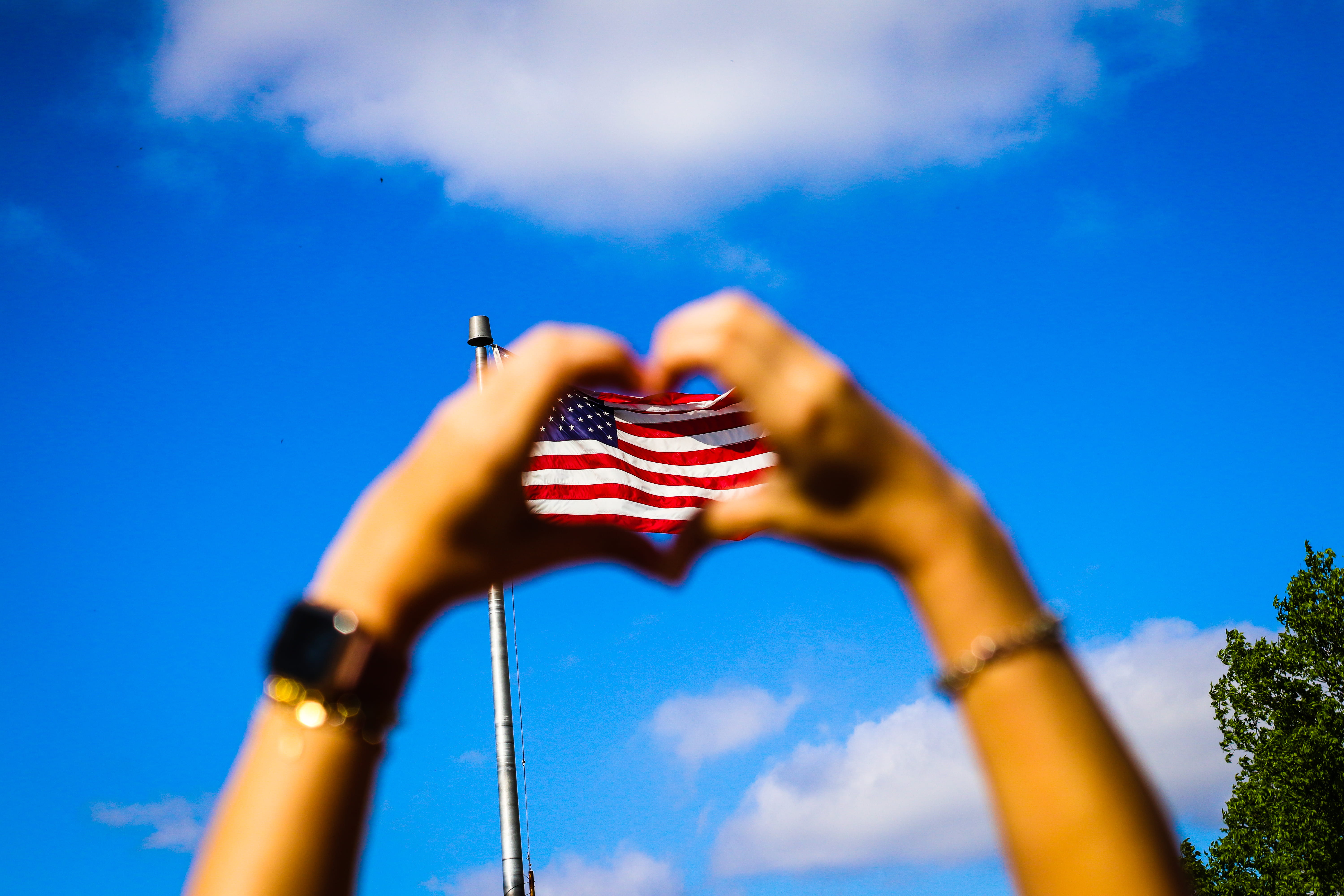 blur, 5K, one person, clouds, america, celebration, nature, wind, us, hand raised, low angle view, festival, flagpole, democracy, day, outdoor, united states of america, HD Wallpaper
