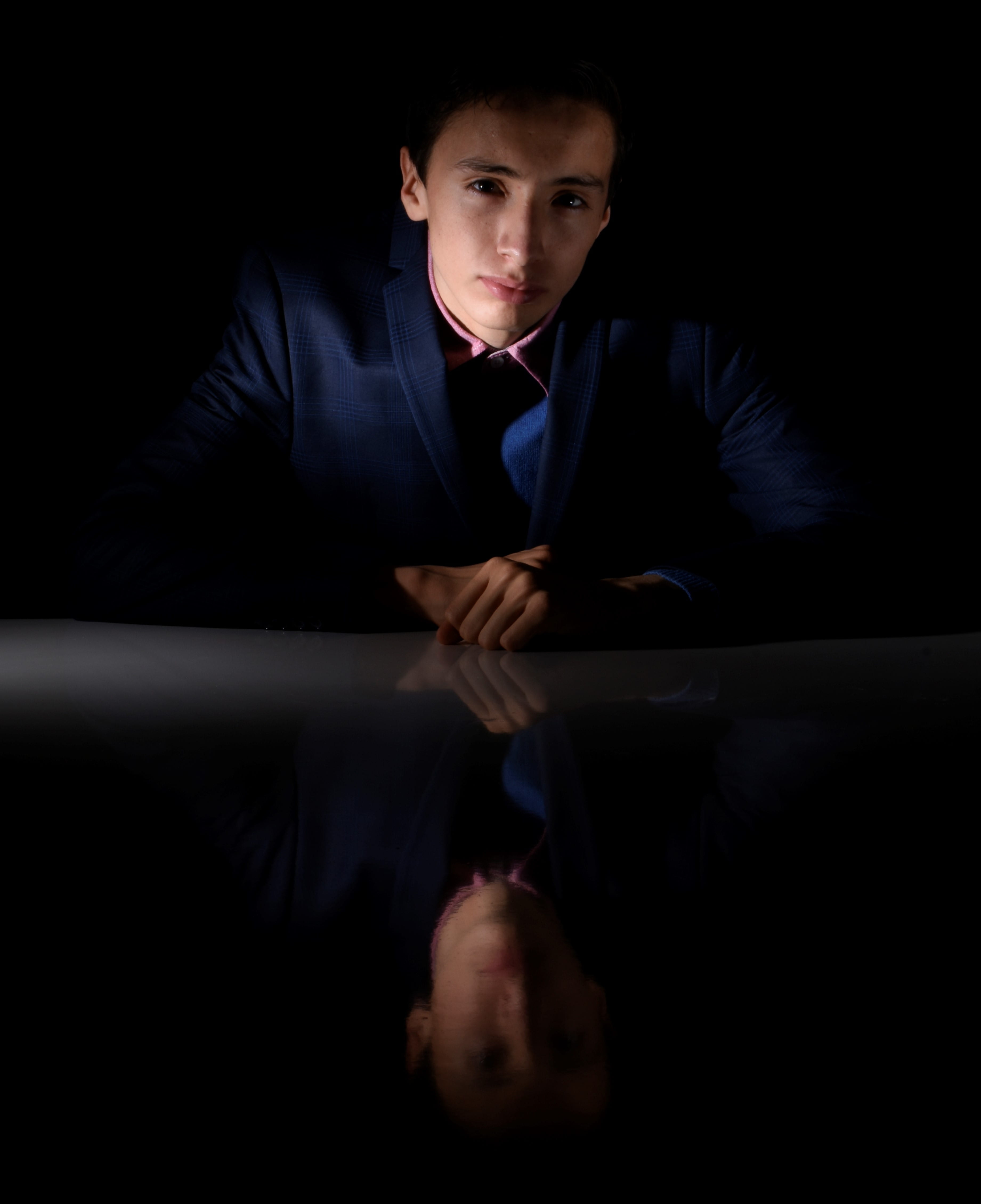 confidence, male, males, suit, sitting, young adult, serious, dark, wearing, blue, business person, looking at camera, man, teenager, model, studio shot, Phone HD Wallpaper