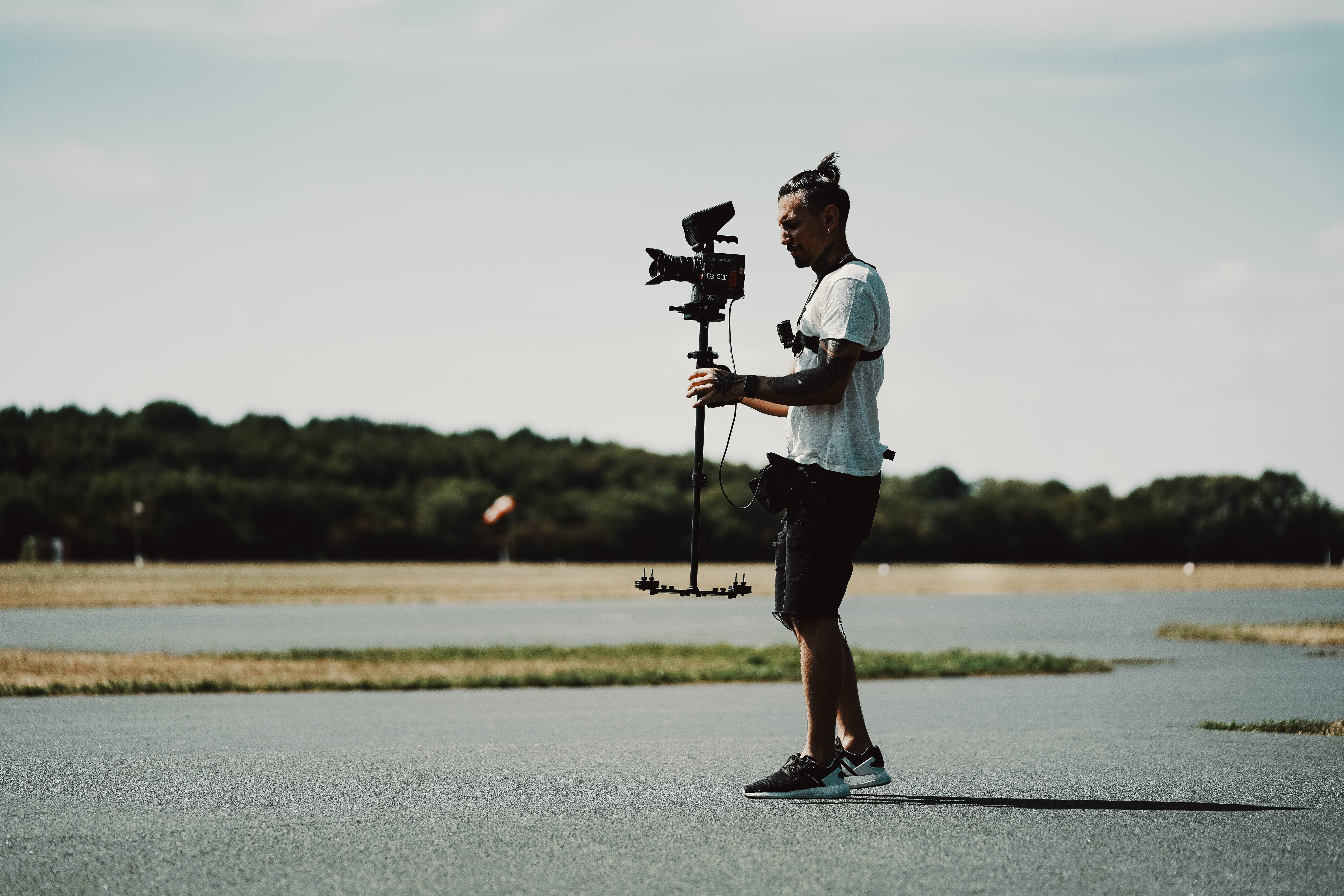 side view, professional, using, tripod, footwear, animal, bird, shorts, full length, day, weaponry, sky, red, gun, photographer, real people, one person, HD Wallpaper