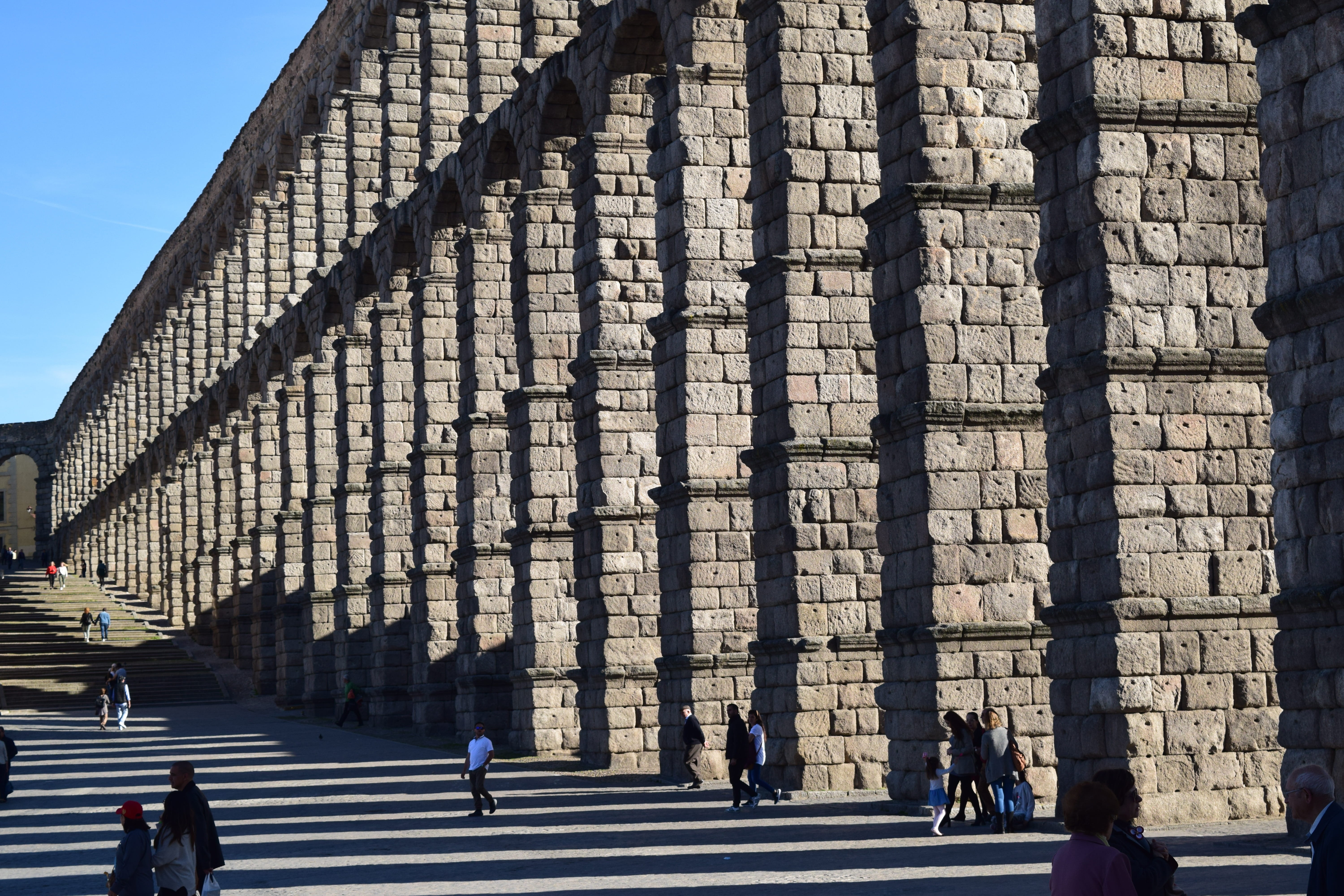 real people, segovia, walking, built structure, travel destinations, shadows, structure, city, historical, building, building exterior, roman, spain, symmetrical, HD Wallpaper