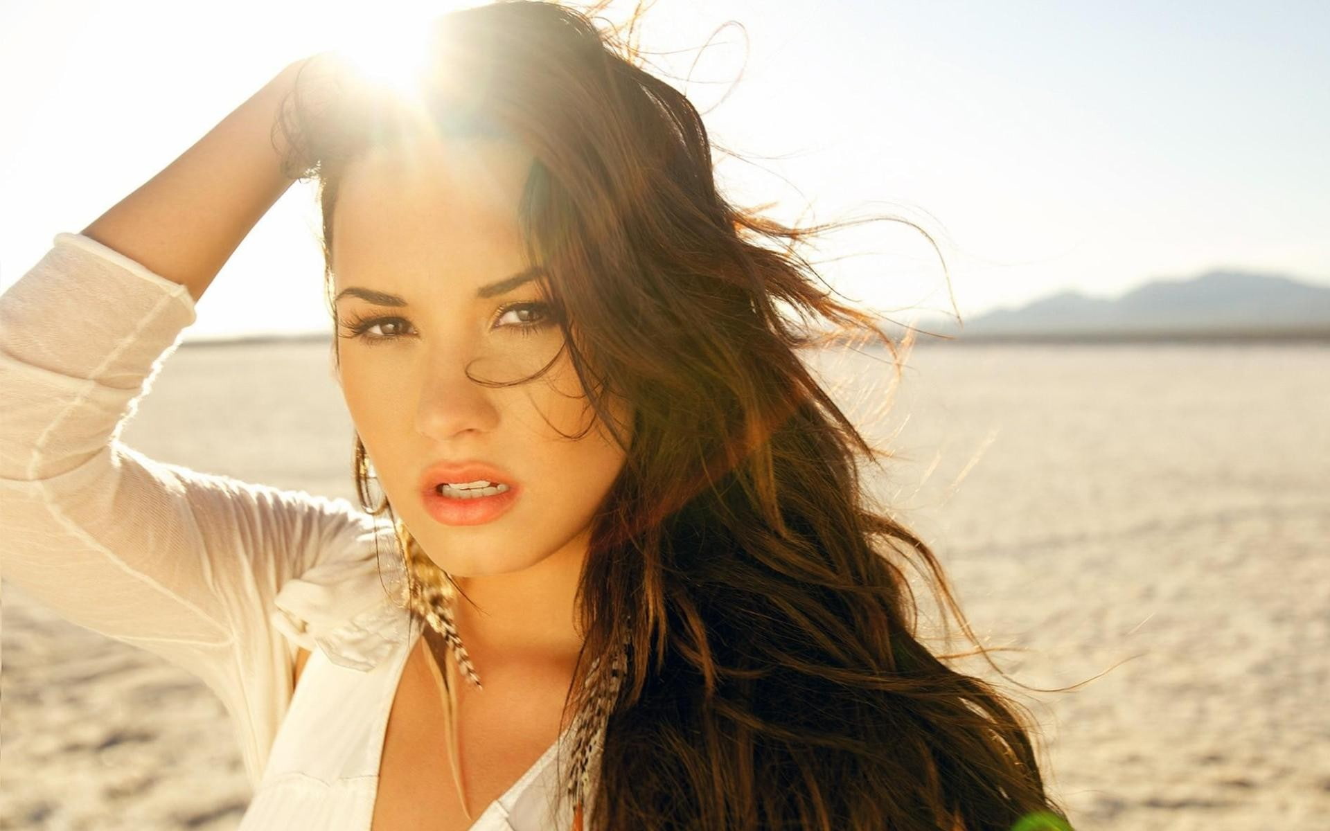 lens flare, long hair, headshot, outdoors, women, fashion, beach, sunlight, Demi Lovato, hands on head, face, human face, hair, wind, 1080P, land, brown hair, HD Wallpaper