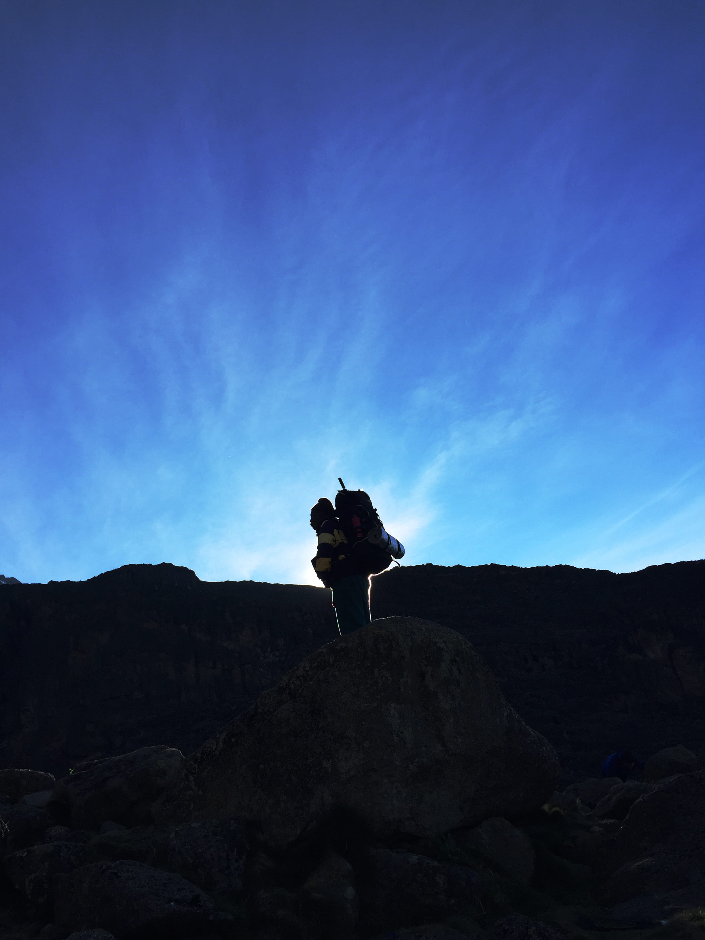 kilimanjaro summit, porter, standing, outdoors, 2K, africa, solid, explore, travel, rock, people, blue, rock - object, one person, full length, mountain, Phone HD Wallpaper