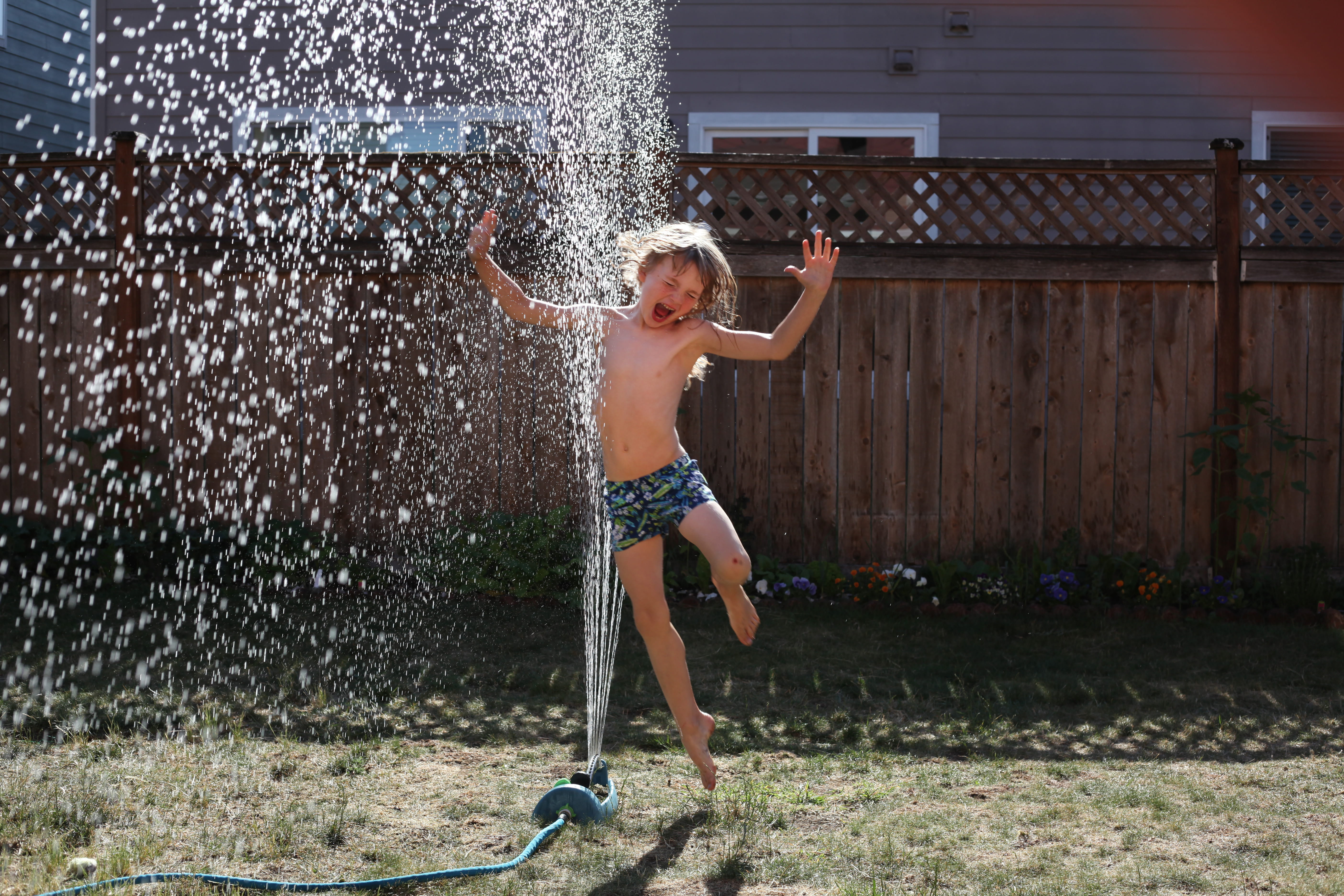 one person, little, facial expression, body part, full length, arms raised, childhood, nature, daylight, motion, young, swimwear, sprinkler, fun, emotion, HD Wallpaper