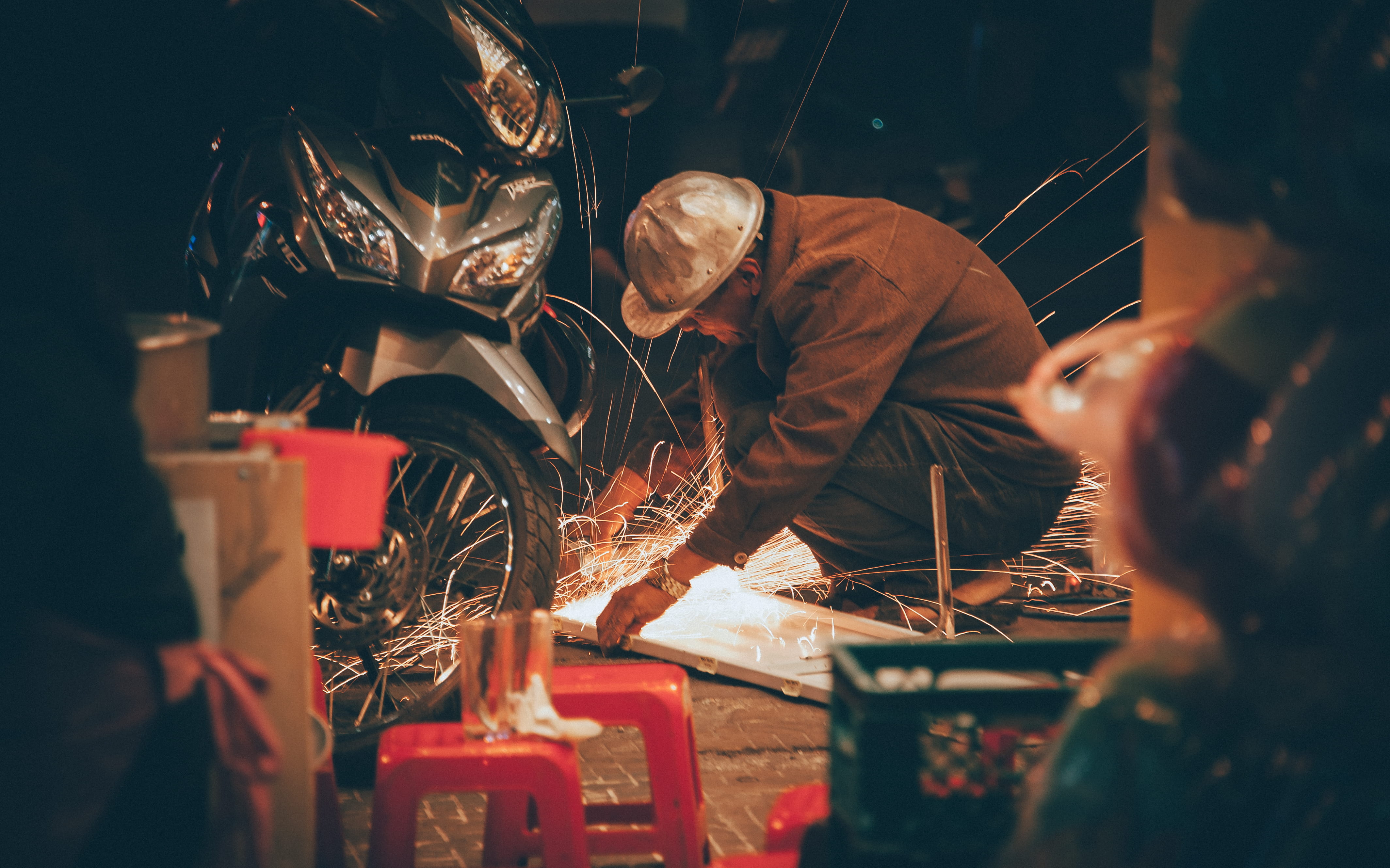 front, motorcycle, grinder, two people, repairing, man, focus on background, photography, spark, real people, selective focus, 4K, brown, metal industry, HD Wallpaper