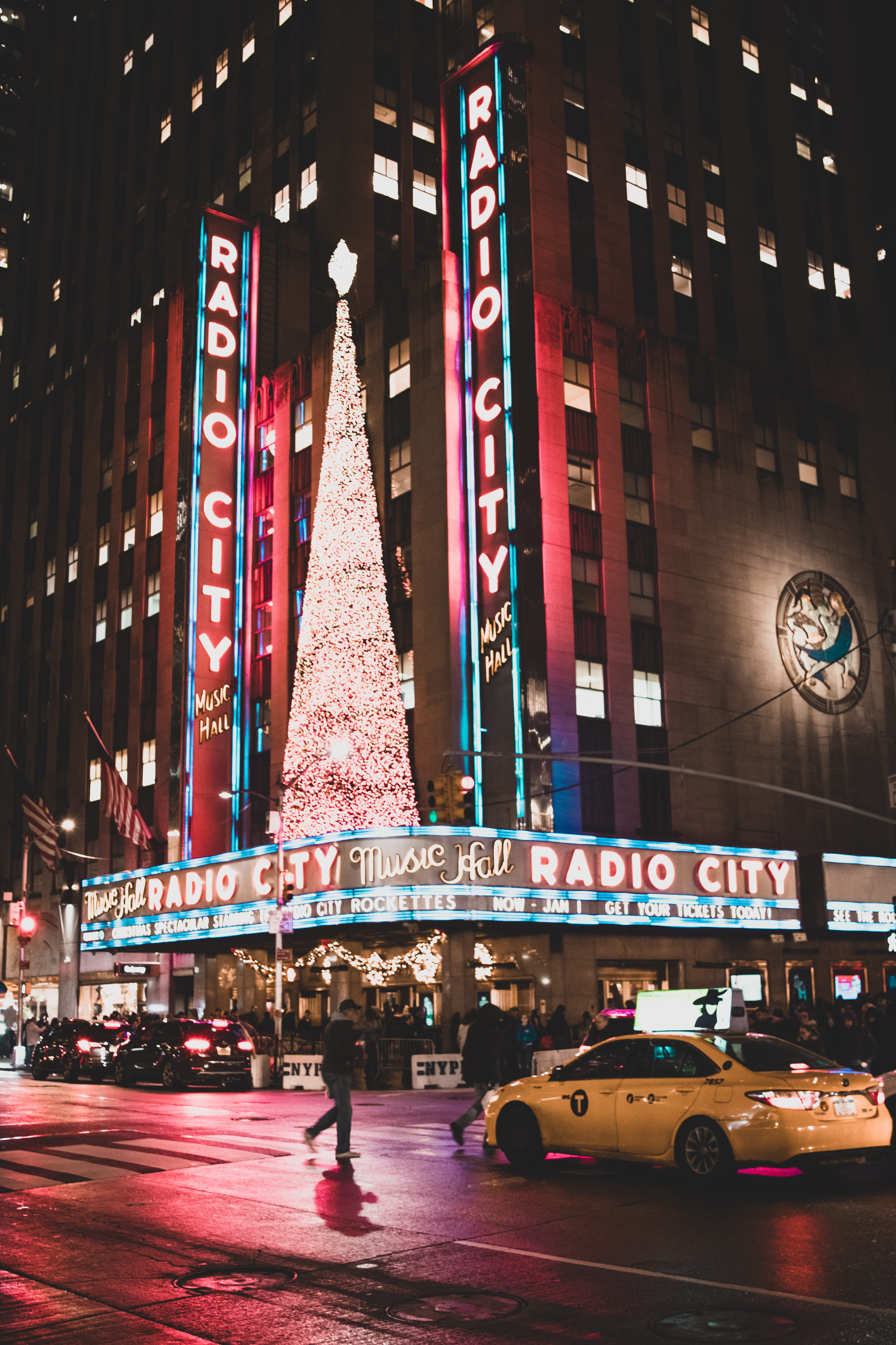 radio city, new york city, land vehicle, building, night photography, celebration, motion, 5K, yellow taxi, mode of transportation, neon signs, building exterior, Phone HD Wallpaper