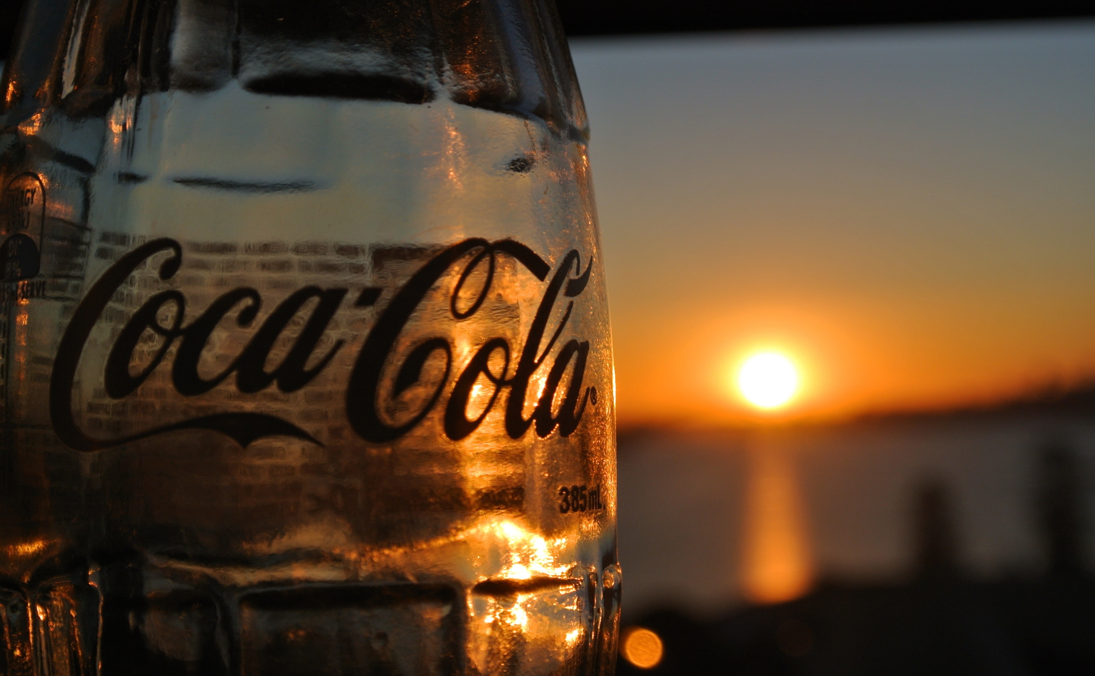 focus on foreground, coca, sun, Nature/Sun and Sky, cola, text, no people, orange color, 4K, drink, refreshment, sunlight, drinking glass, still life, HD Wallpaper