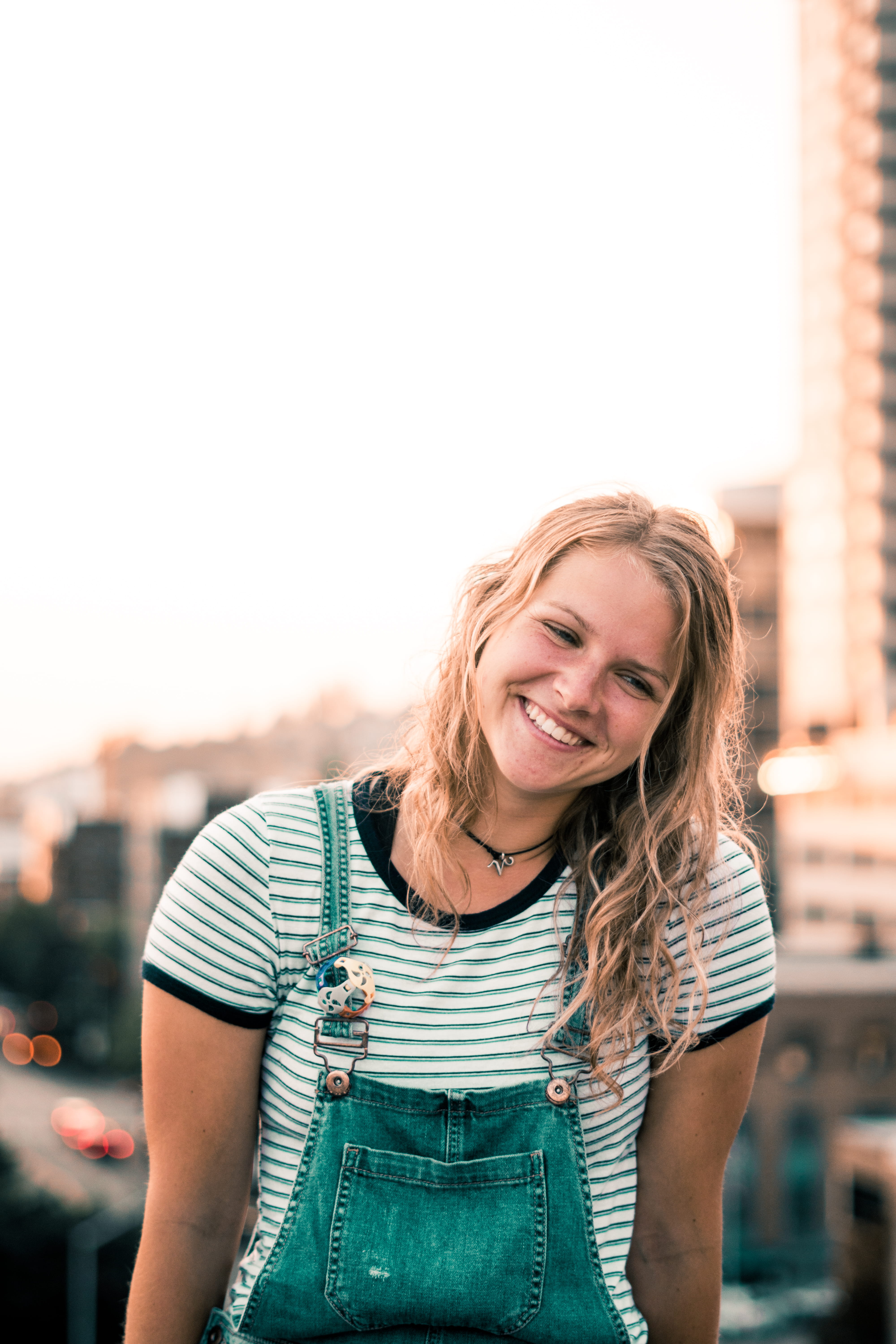 beauty, looking at camera, front view, outdoors, standing, 5K, emotion, young adult, smiling, blue, adult, architecture, dungarees, woman, hairstyle, denim, Phone HD Wallpaper