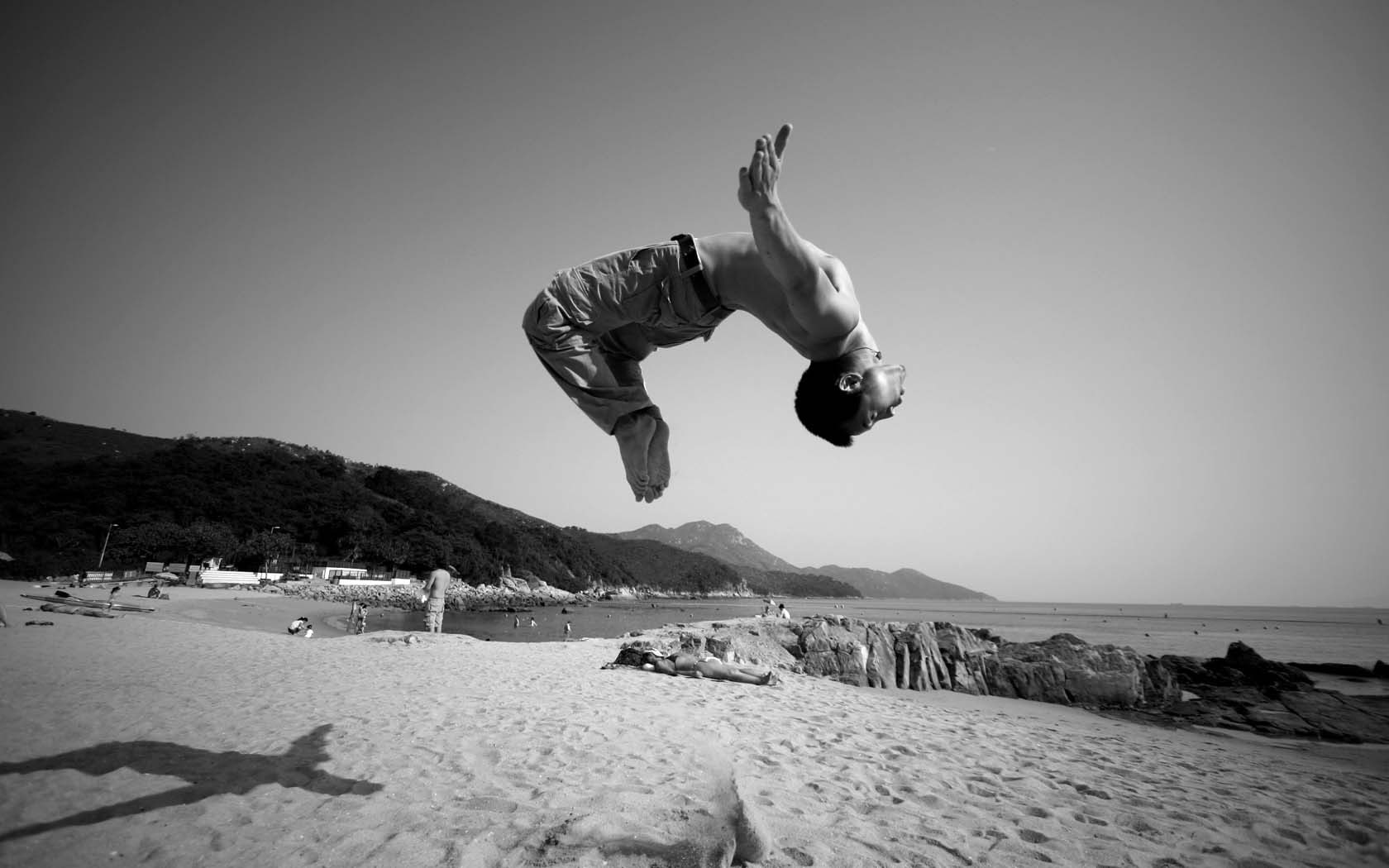 beach, sky, mid-air, lifestyles, water, motion, 720P, monochrome, real people, men, jumping, nature, full length, one person, outdoors, sand, land, leisure activity, HD Wallpaper