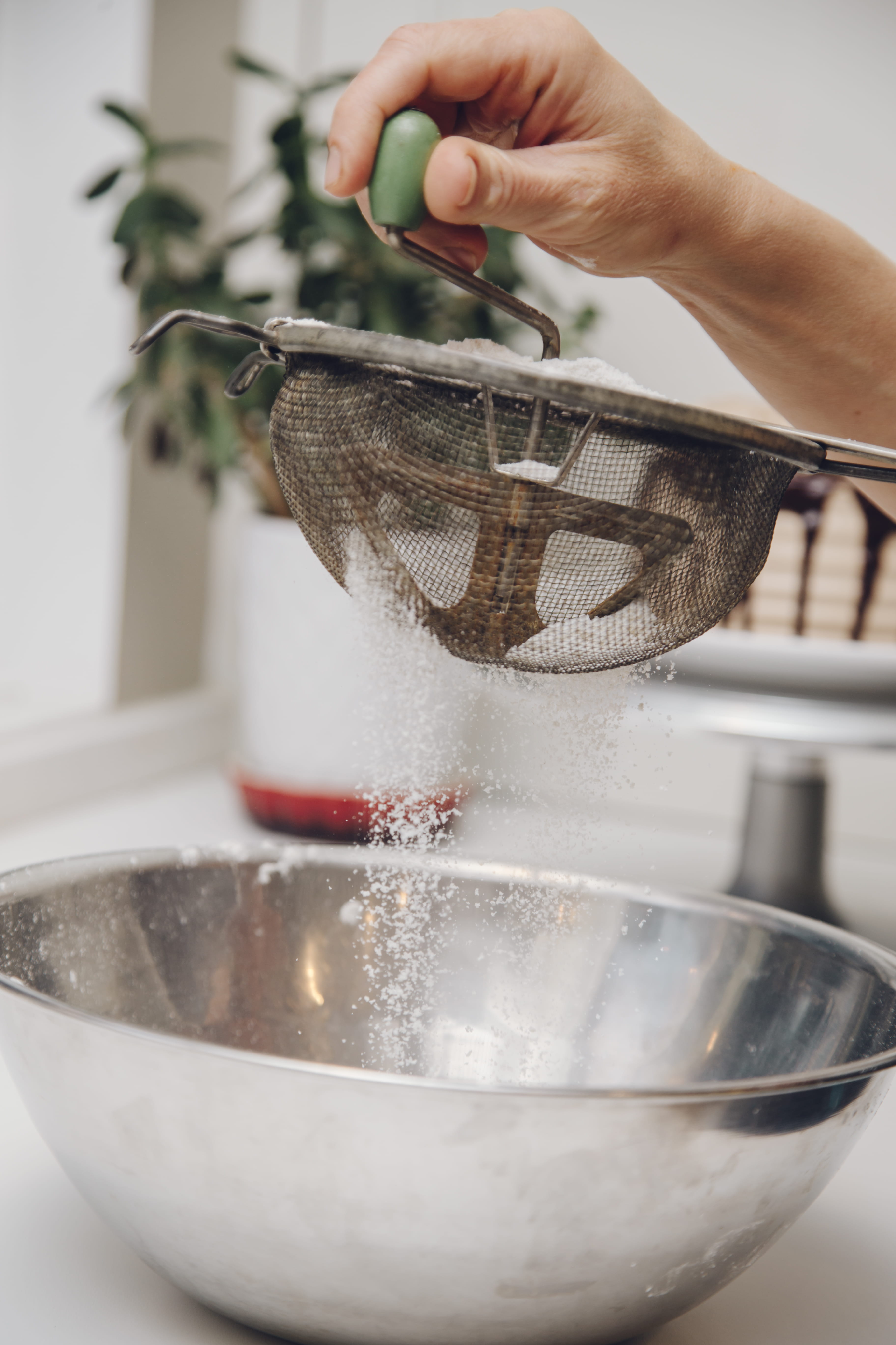 filtering, drizzling, indoors, holding, bowl, unrecognizable person, kitchen, drizzle, human hand, strainer, kitchen ware, preparation, sugar, domestic kitchen, Phone HD Wallpaper