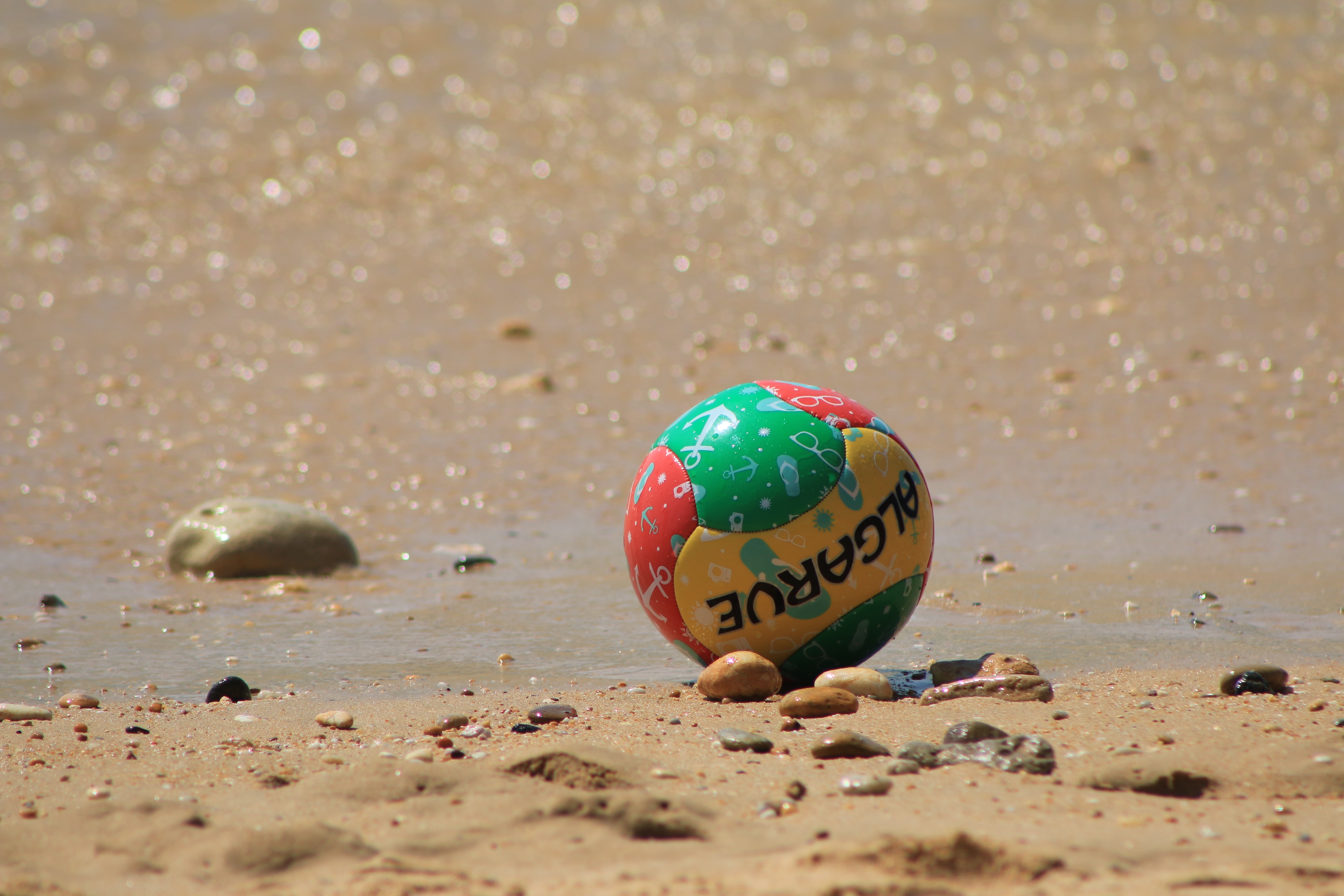 sphere, algarve, sunlight, shell, outdoors, beach football, communication, pebble, colored ball, water, holidays, green color, text, summer, beach, 5K, HD Wallpaper