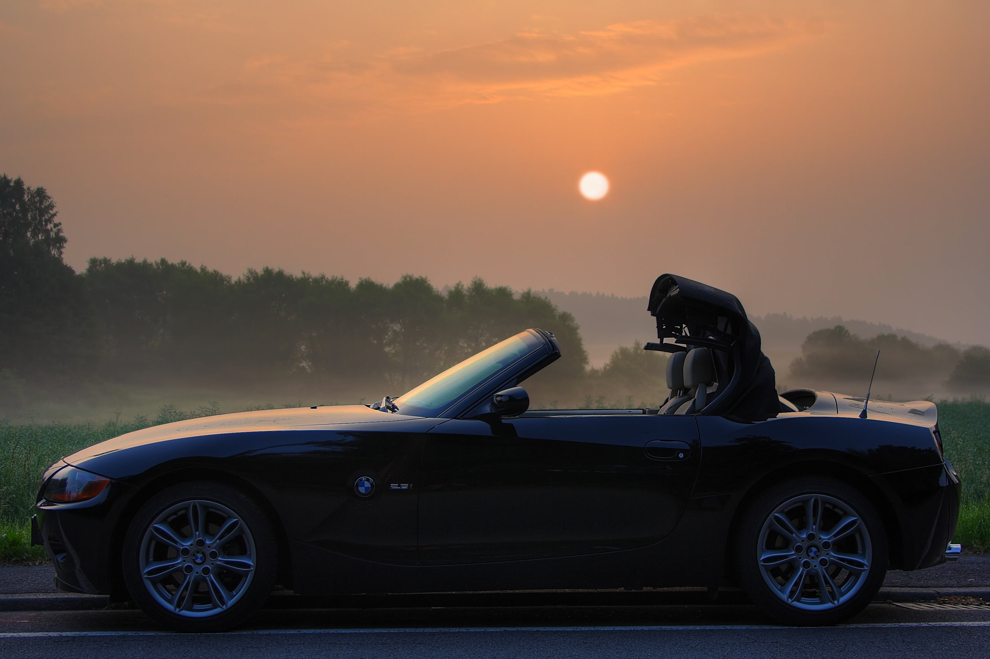 pkw, black, coupe, sunset, parked, roadster, nature, motor vehicle, one person, sky, side view, 2K, outdoors, travel, adventure, road, sunlight, sunrise, HD Wallpaper