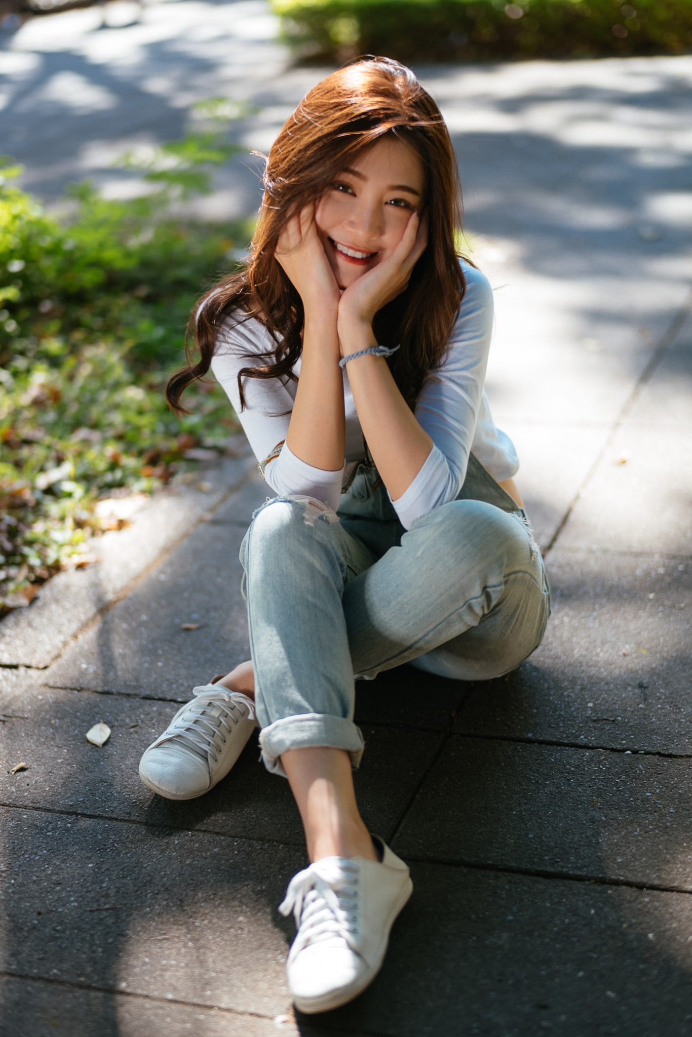 brunette, portrait display, white tops, women outdoors, overalls, legs crossed, depth of field, Asian, denim, women, model, sitting, outdoors, looking at viewer, Phone HD Wallpaper