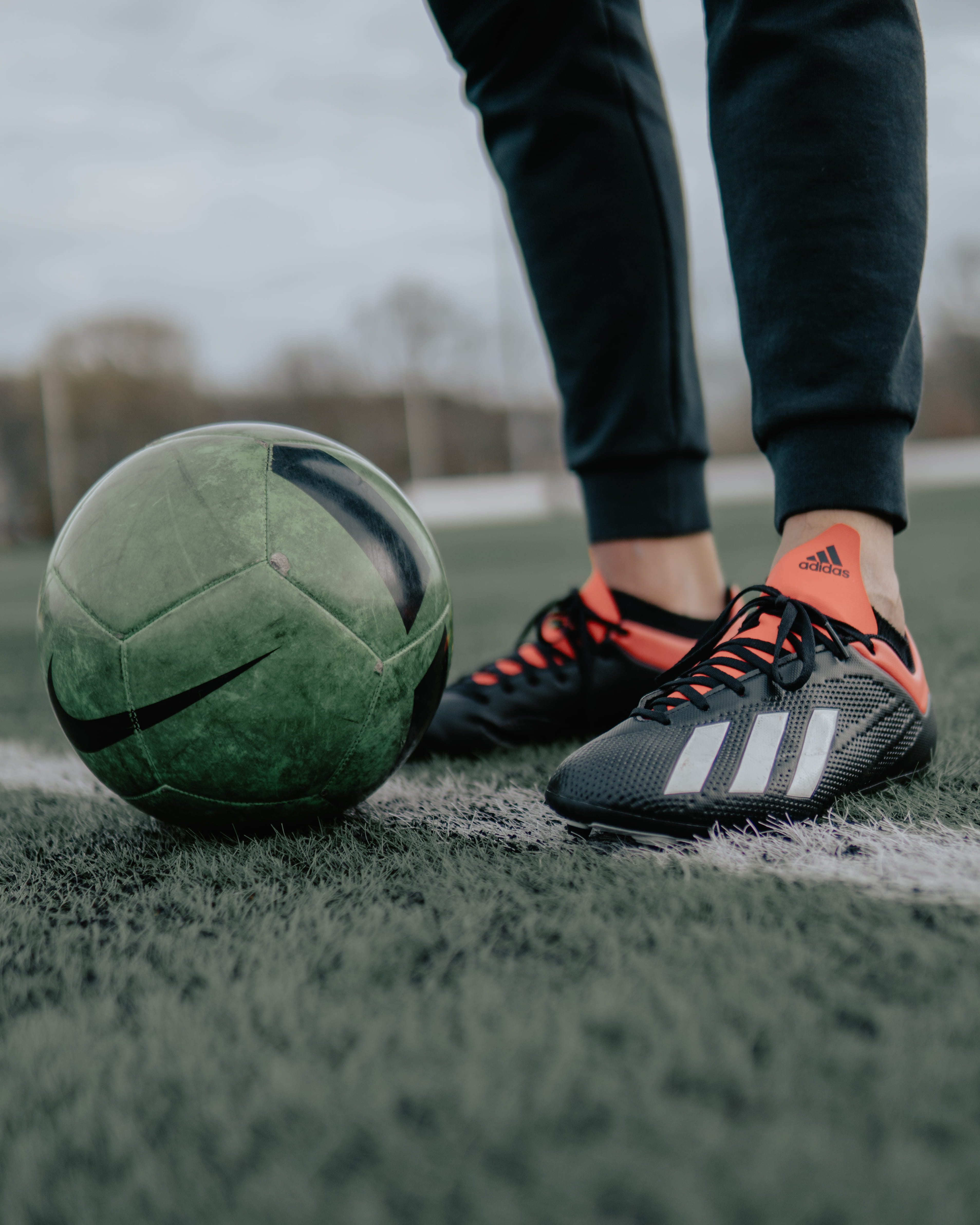 human foot, black, leather, human leg, body part, ball, standing, day, person, sports equipment, beside, outdoors, nike, sport, focus on foreground, low section, Phone HD Wallpaper