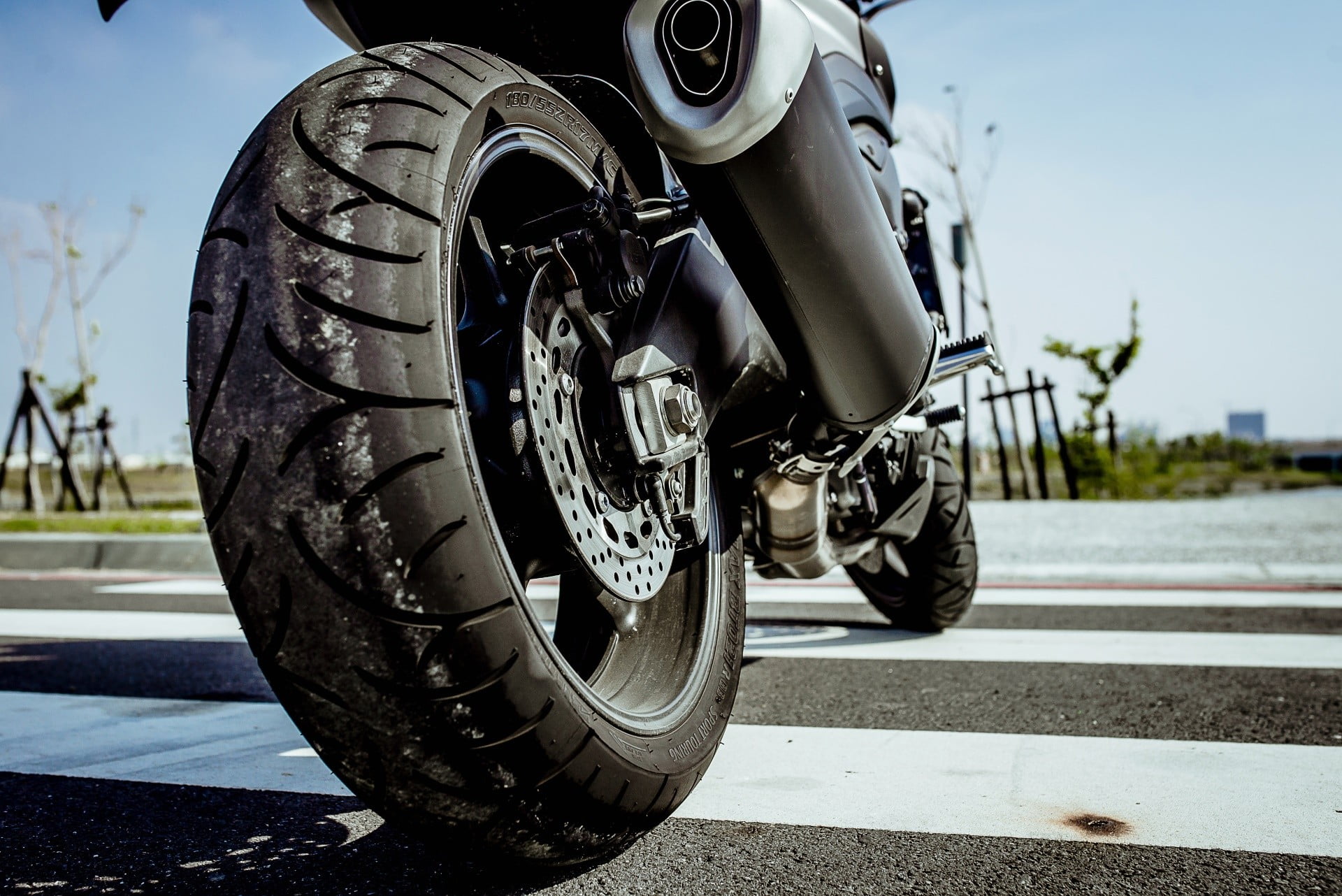 street, stationary, focus on foreground, motorcycle, sunlight, black, vehicle part, sign, tire, transportation, 1080P, road, wheels, wheel, day, outdoors, HD Wallpaper