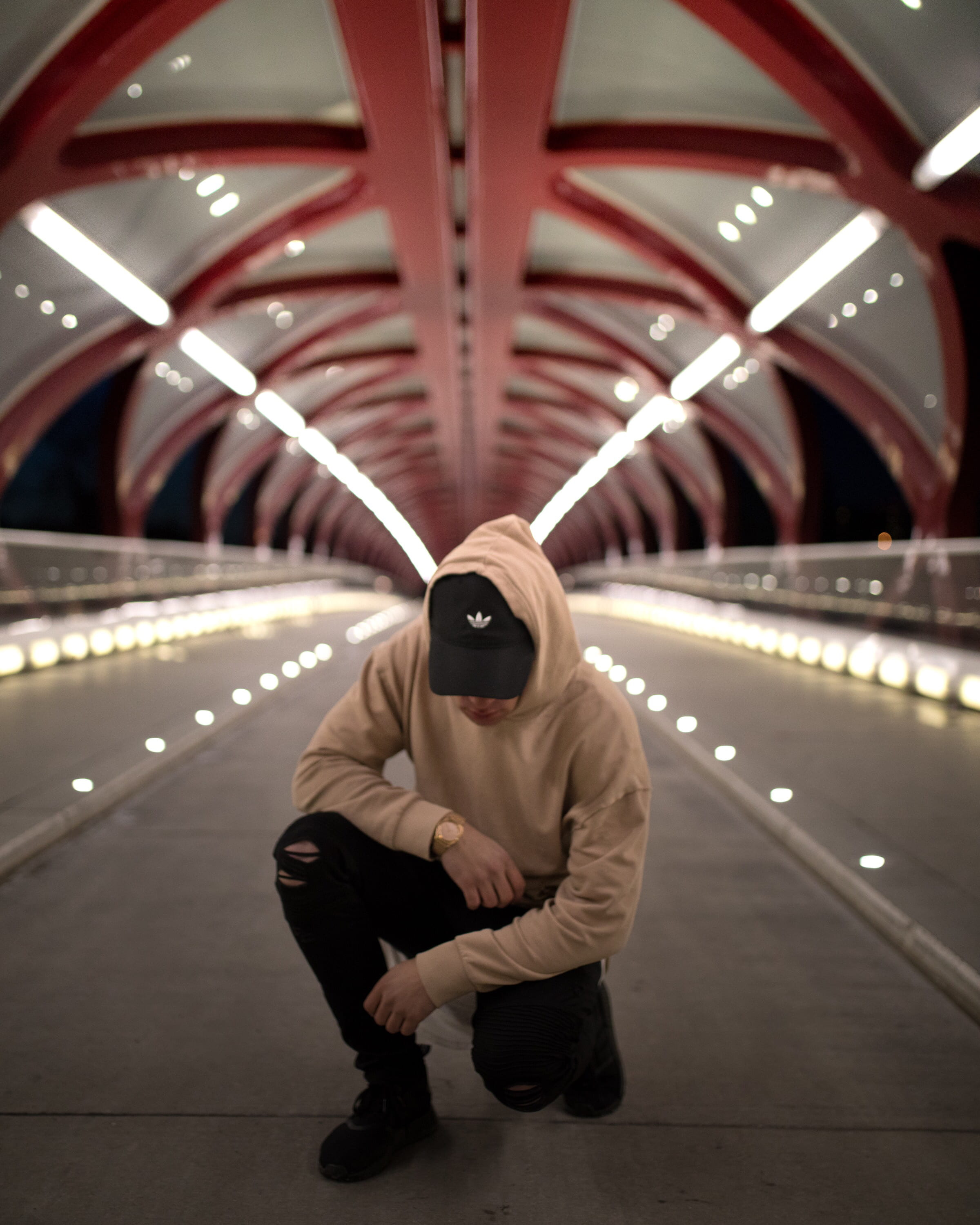 front view, built structure, real people, keed, clothing, knee, young adult, hoodie, center, casual clothing, architecture, wrist watch, man, brown, bridge - man made structure, Phone HD Wallpaper