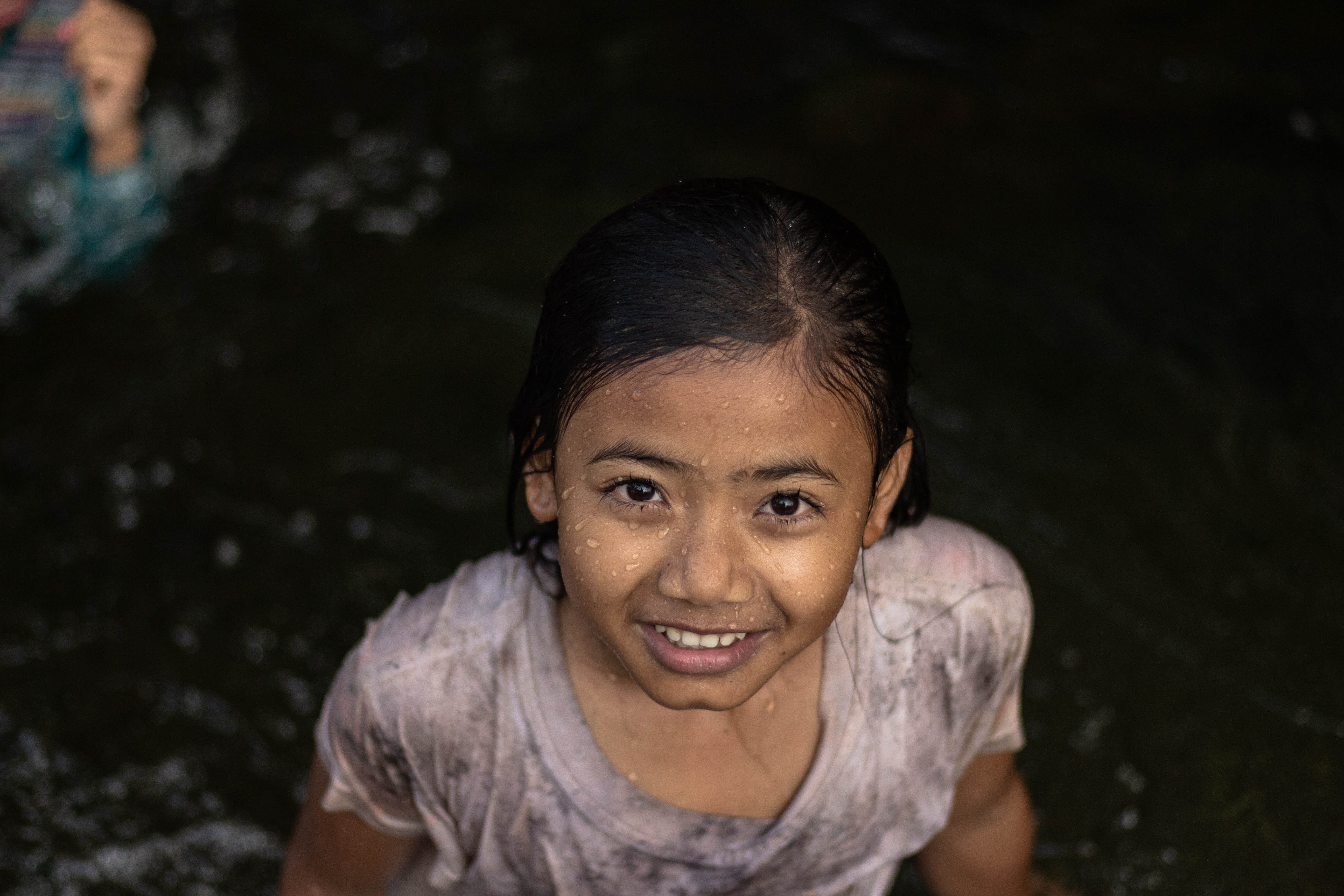village, river, portrait, hair, emotion, one person, face, happiness, cake, human, looking at camera, jungle, water, plant, girl, casual clothing, black hair, HD Wallpaper
