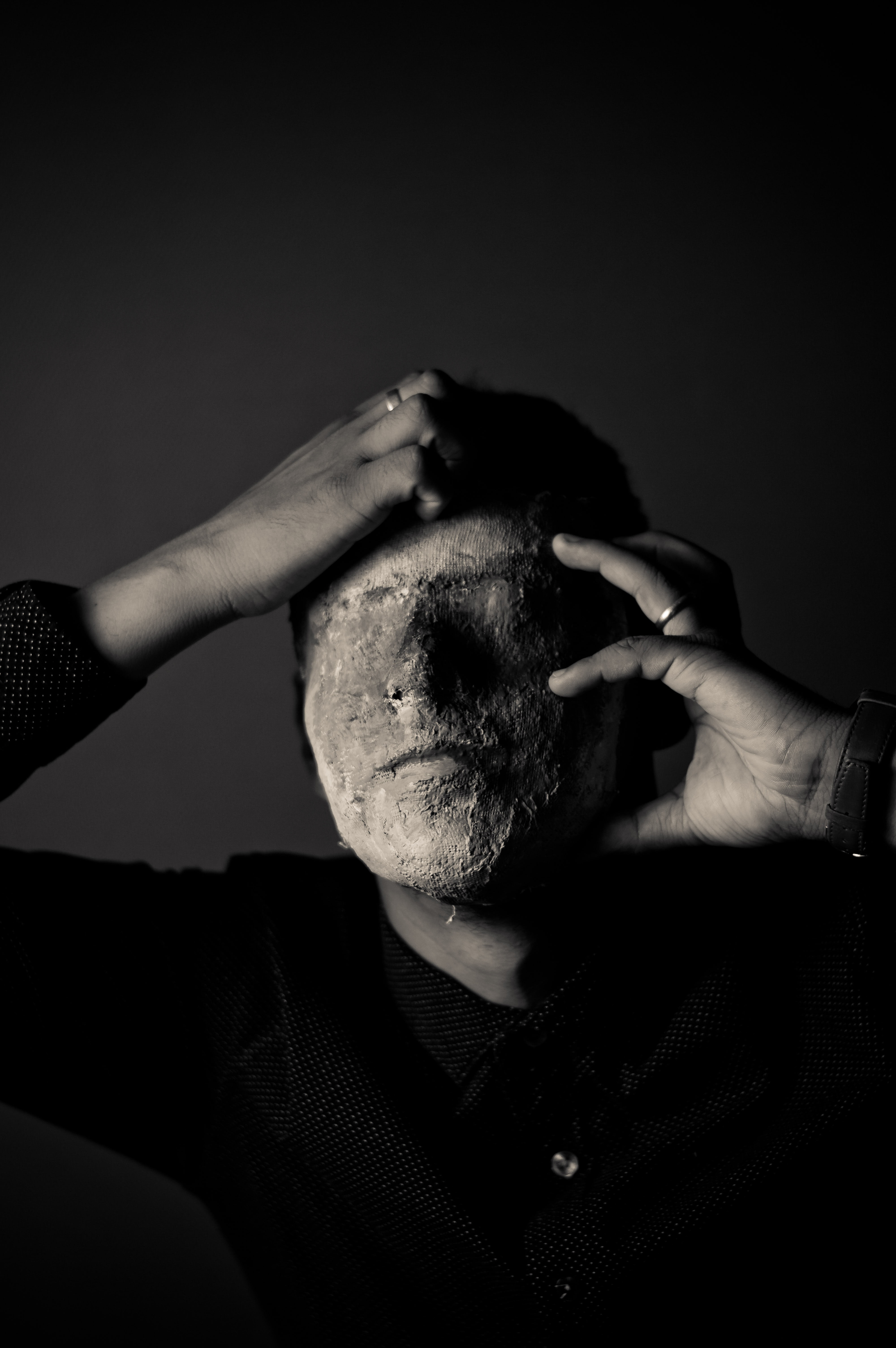 black Background, human hand, indoors, males, white, leisure activity, mask, man, makeup, facial hair, looking at camera, mud, close-up, dark, holding, Phone HD Wallpaper
