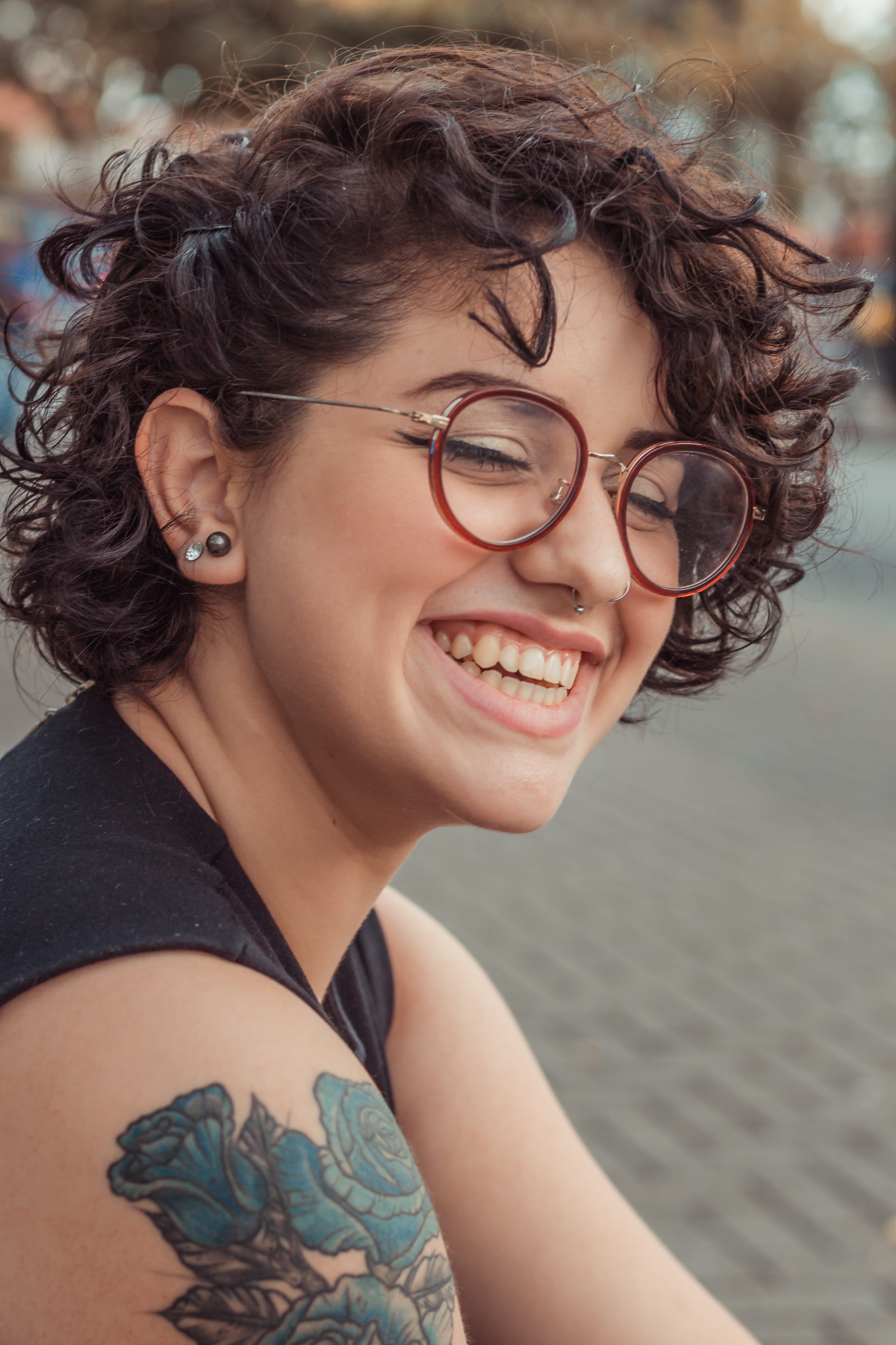 cute, happiness, tattooed, happy, eyes, young adult, sitting, lifestyles, one person, glasses, tatoo, front view, real people, 2K, facial expression, concrete, Phone HD Wallpaper