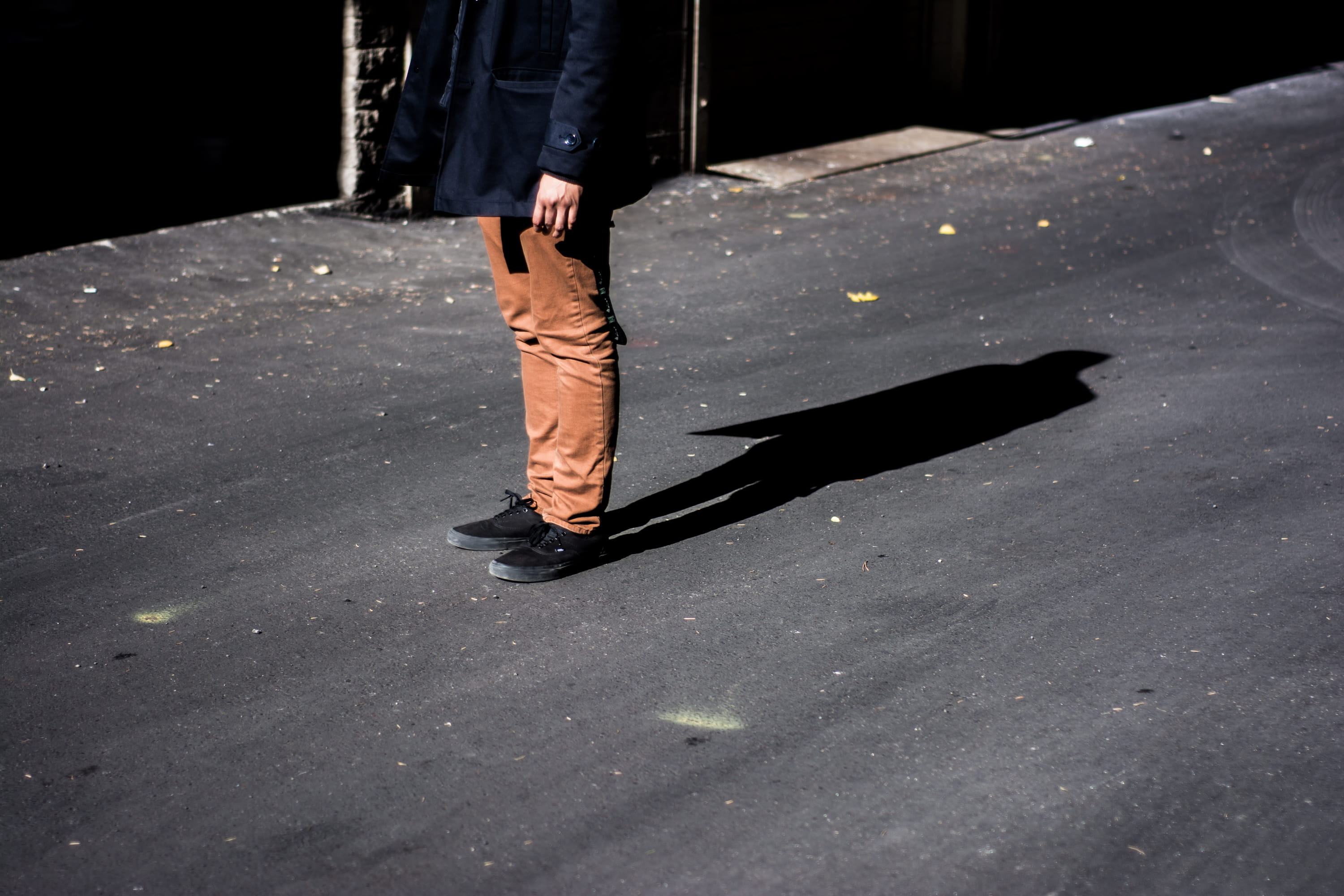 lifestyles, one Person, body part, city, photography, daytime, standing, human body part, human foot, black coat, person, sunlight, pants, women, shadow, HD Wallpaper