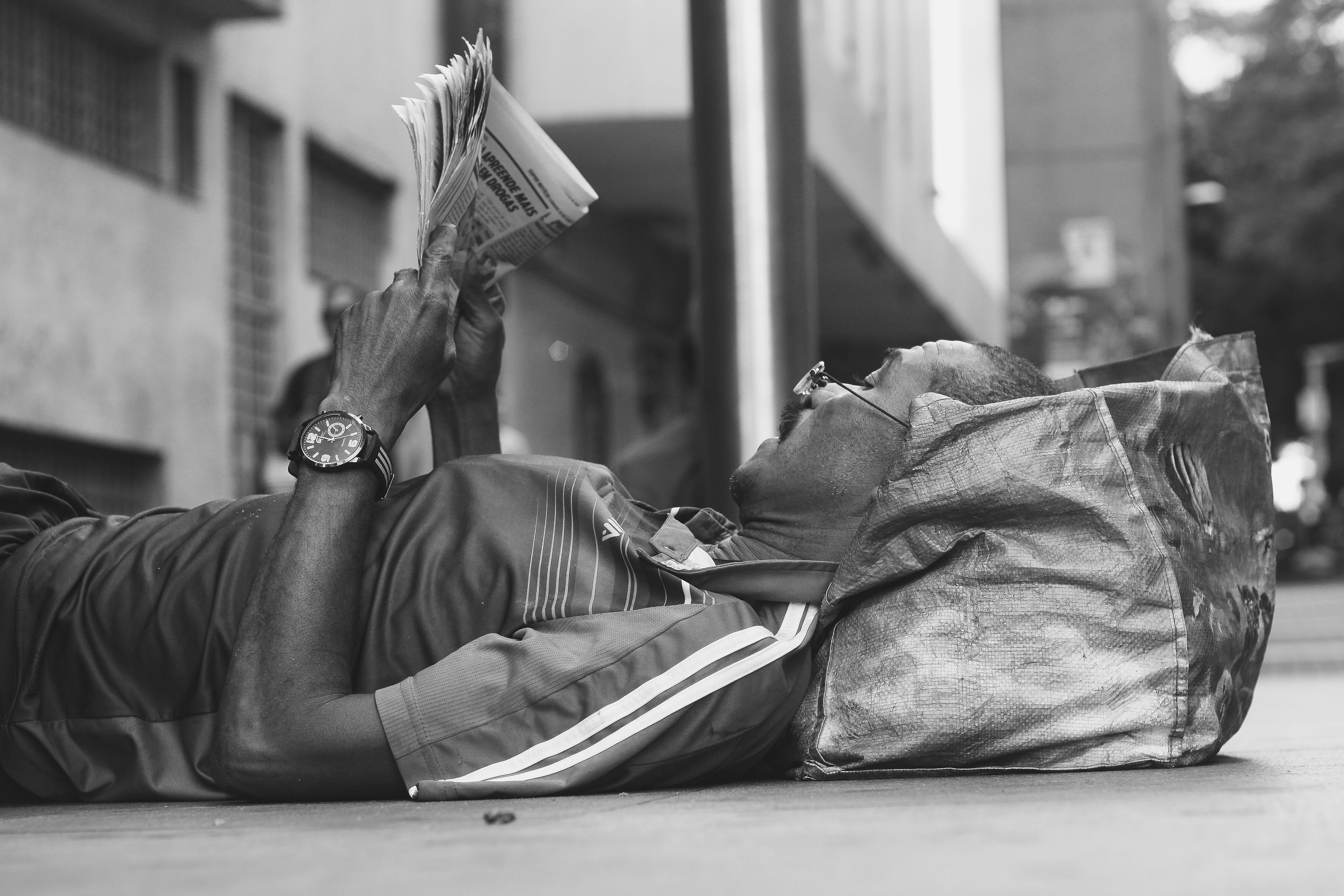 lifestyles, men, black And White, ground, eyeglasses, day, lying on back, holding, indoors, one person, obscured face, relaxation, reading, person, social issues, HD Wallpaper